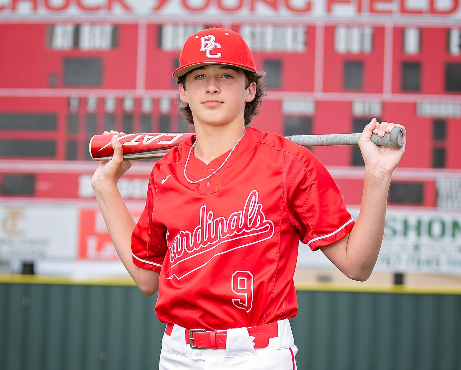 Baseball players in red jerseys pose together in a series of connected photos on a baseball field.