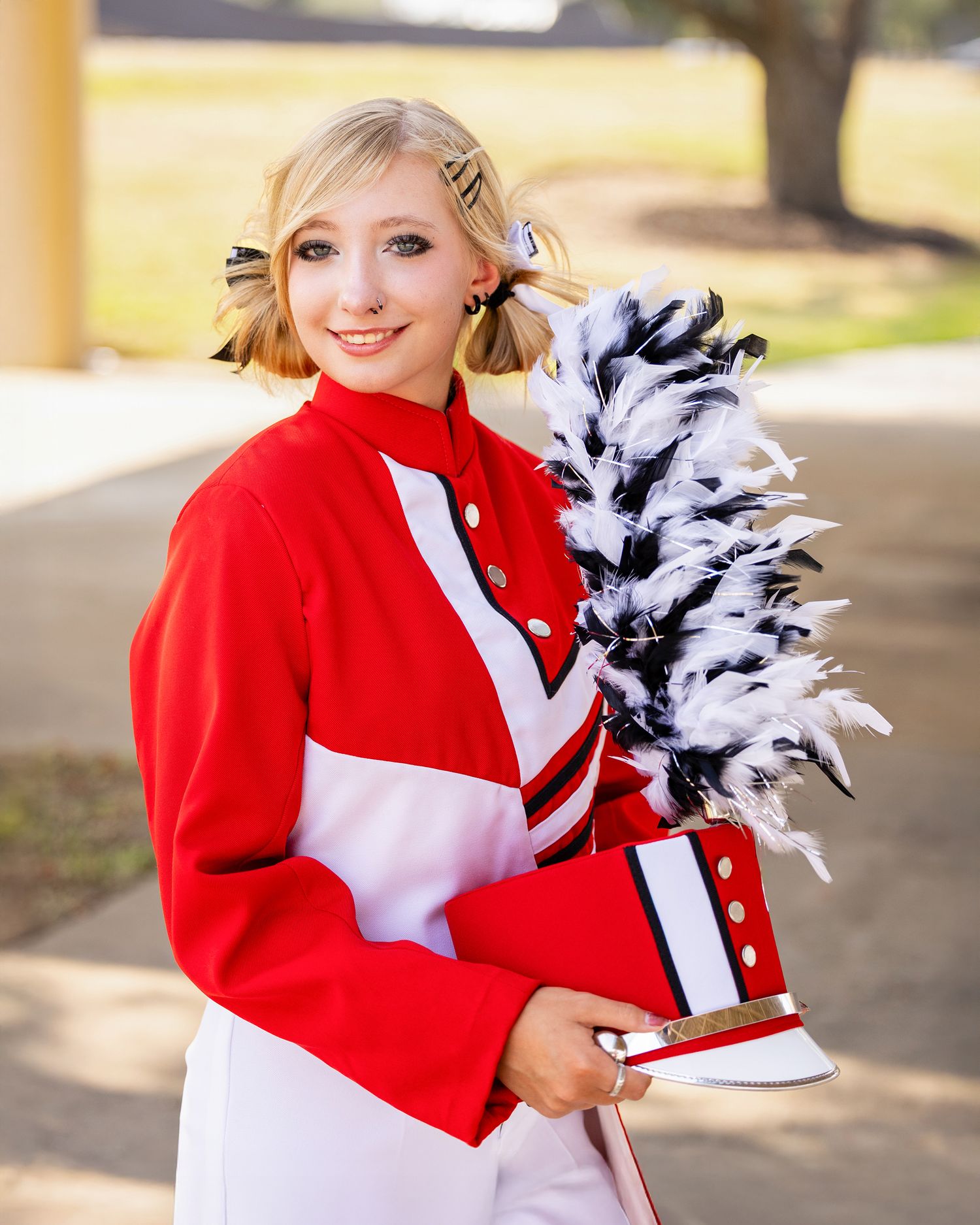 A cheerleader in a red and white uniform with pom poms poses outdoors in a series of four similar shots.