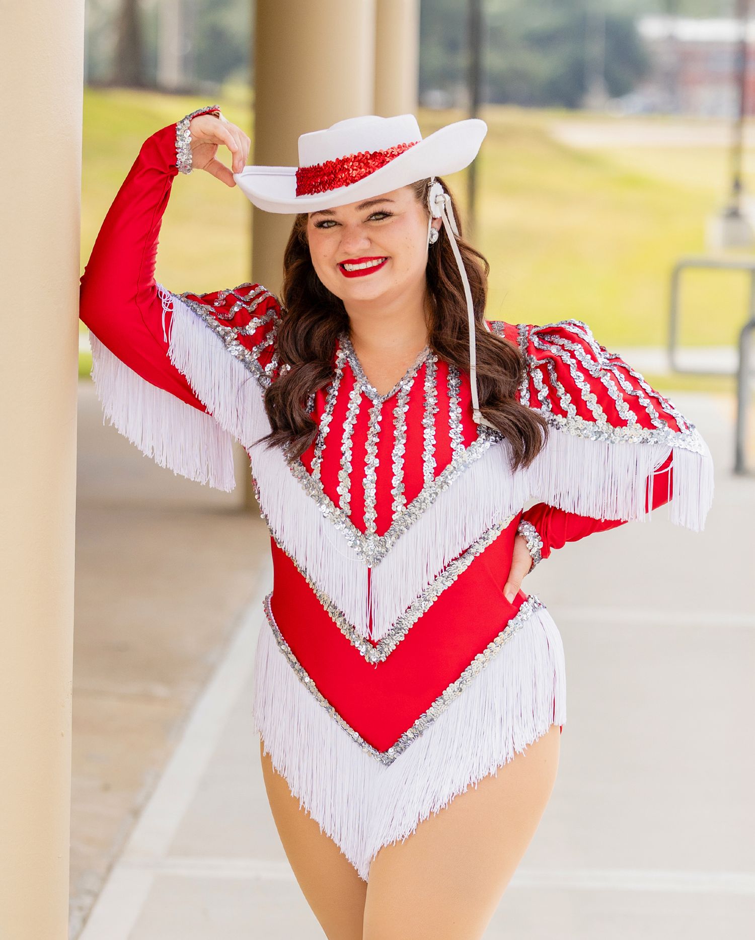 Eisley a member of the Strutters in red and white fringe uniform poses gracefully in three sequential photos outdoors.