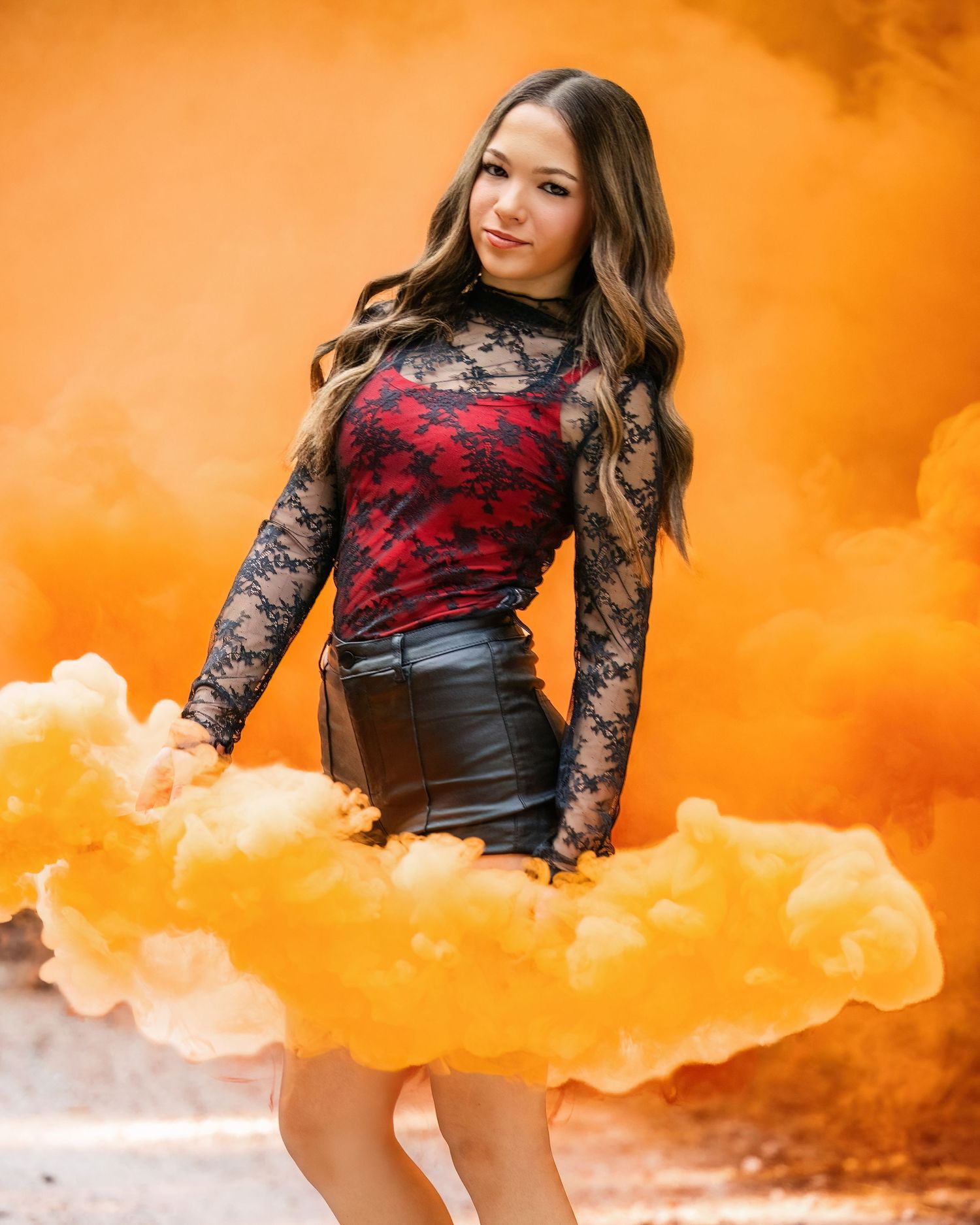Dramatic portrait series with orange smoke effects and black lace outfit creating moody atmosphere.