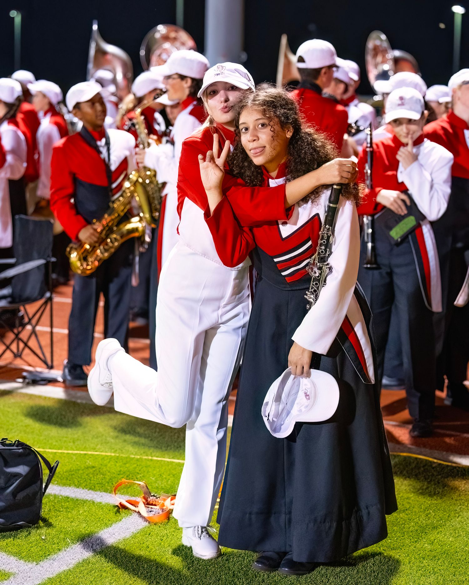 Marching band members in uniforms line up on the field during a performance.
