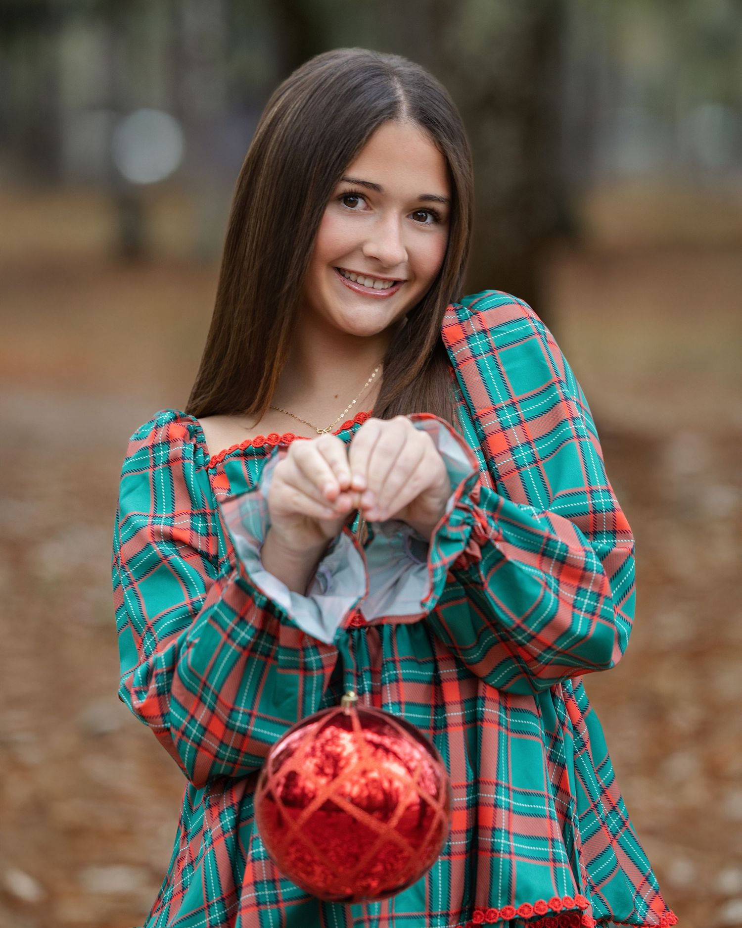 A series of festive photos showing someone in a green plaid shirt holding a red Christmas ornament in a forest setting.