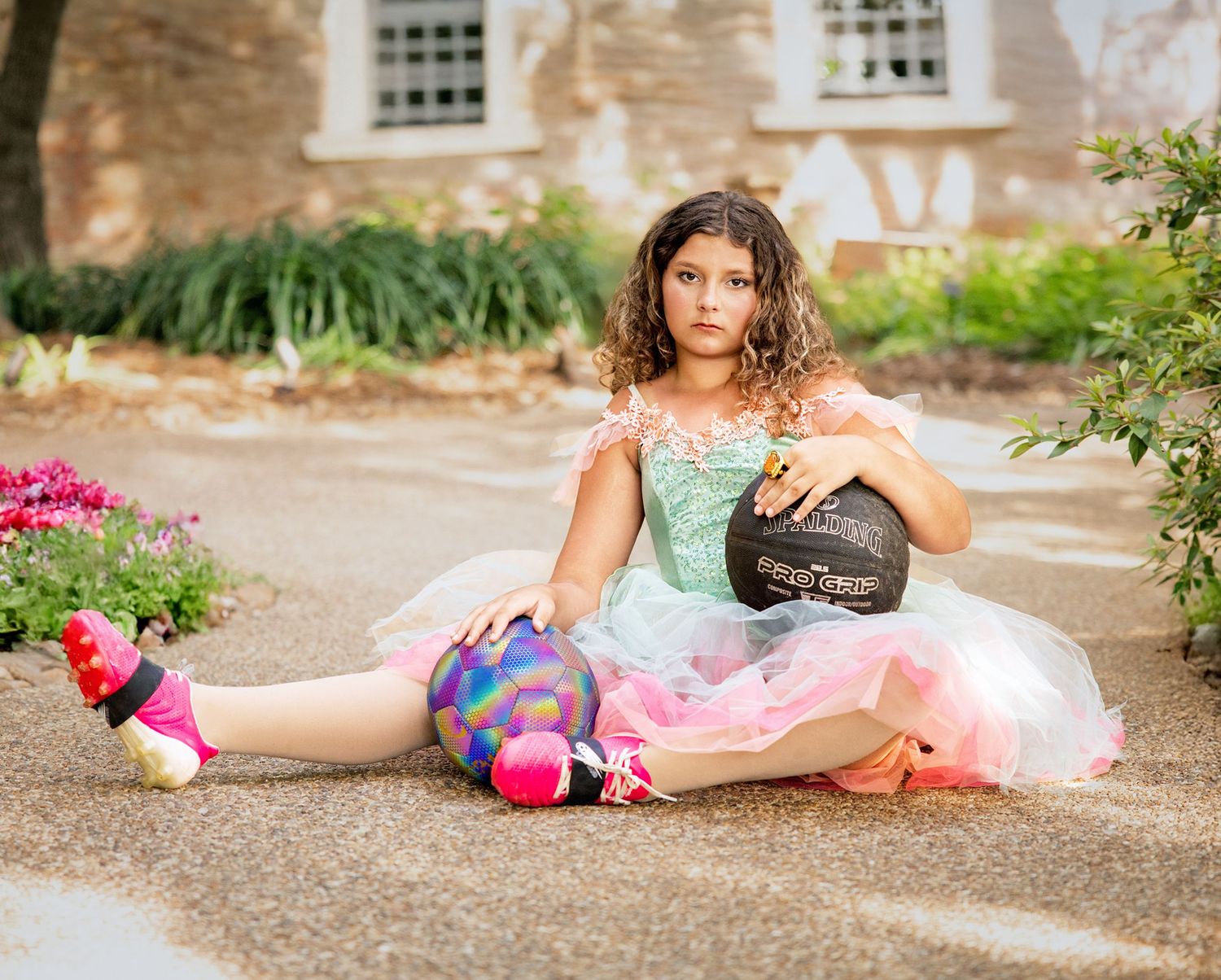 A dreamy fashion scene with a flowing pink tulle skirt and teal corset against a rustic brick wall background.