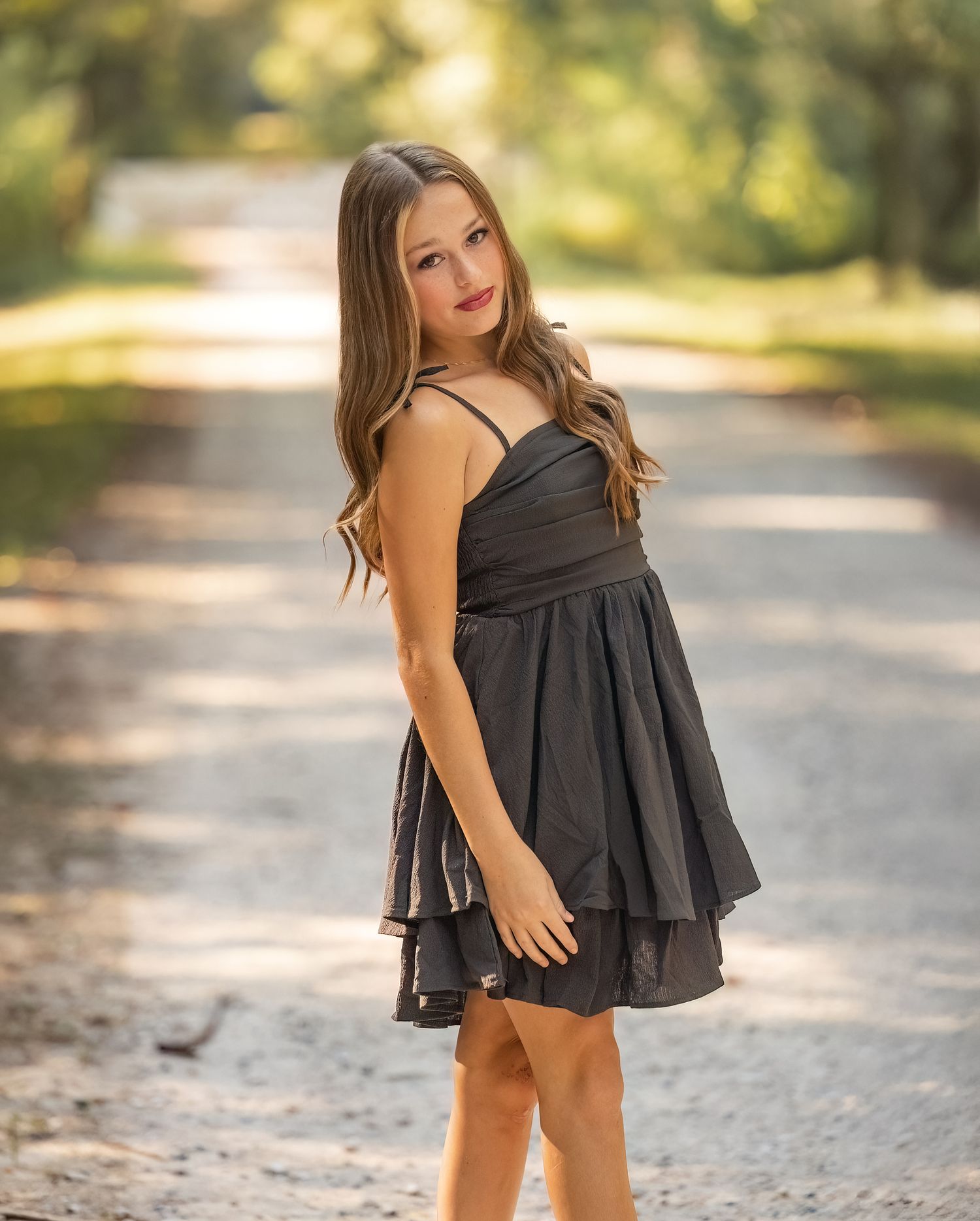 A series of photos showing a black ruffled dress against a sunlit outdoor path with bokeh background.