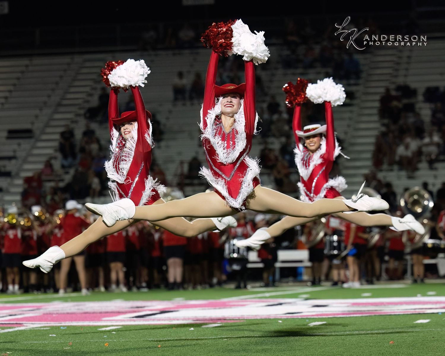 Three Strutters in red and white uniforms perform synchronized in a stunning routine.