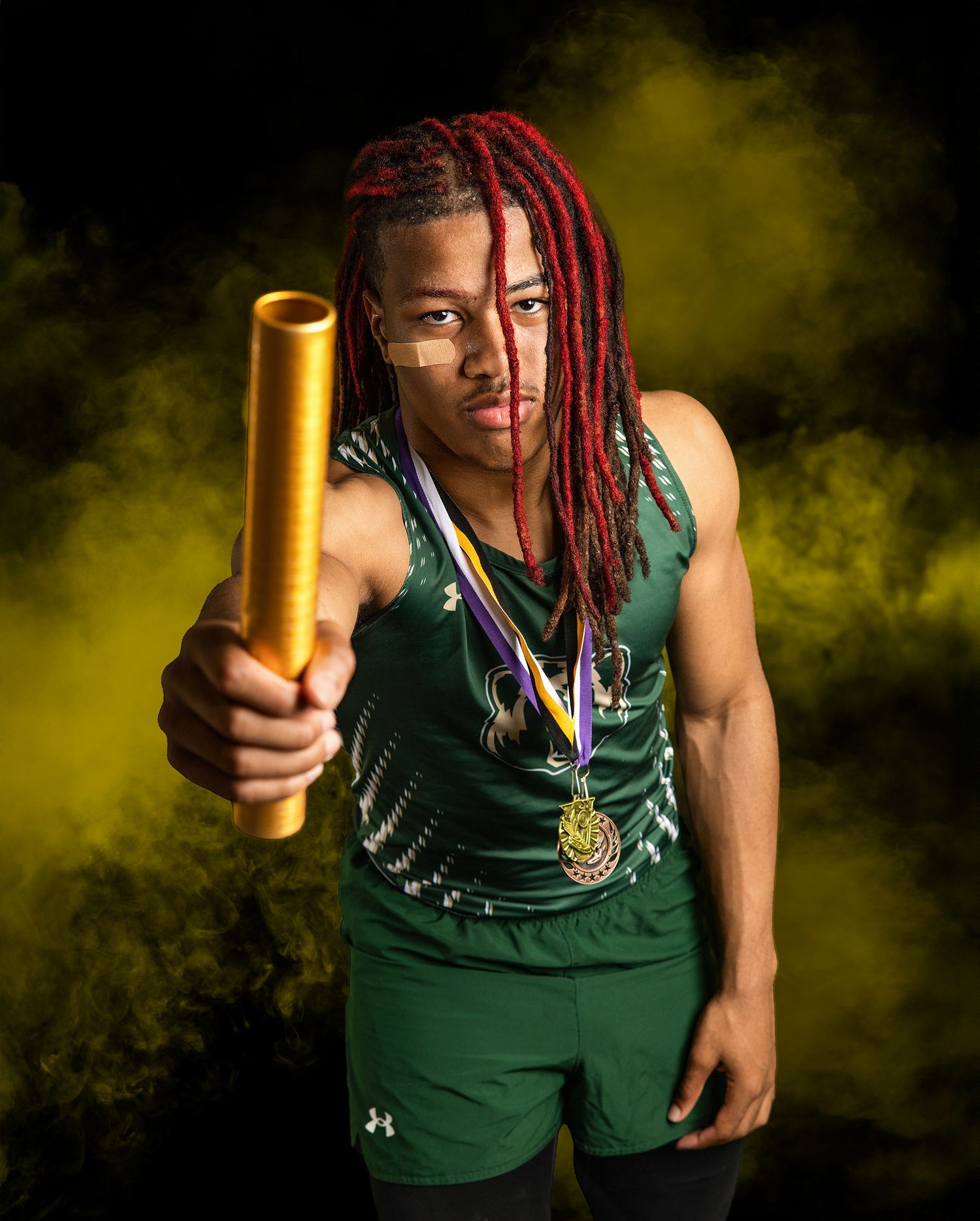 LCM Track athlete in green uniform holds gold relay baton against dramatic yellow smoke background in dynamic poses.