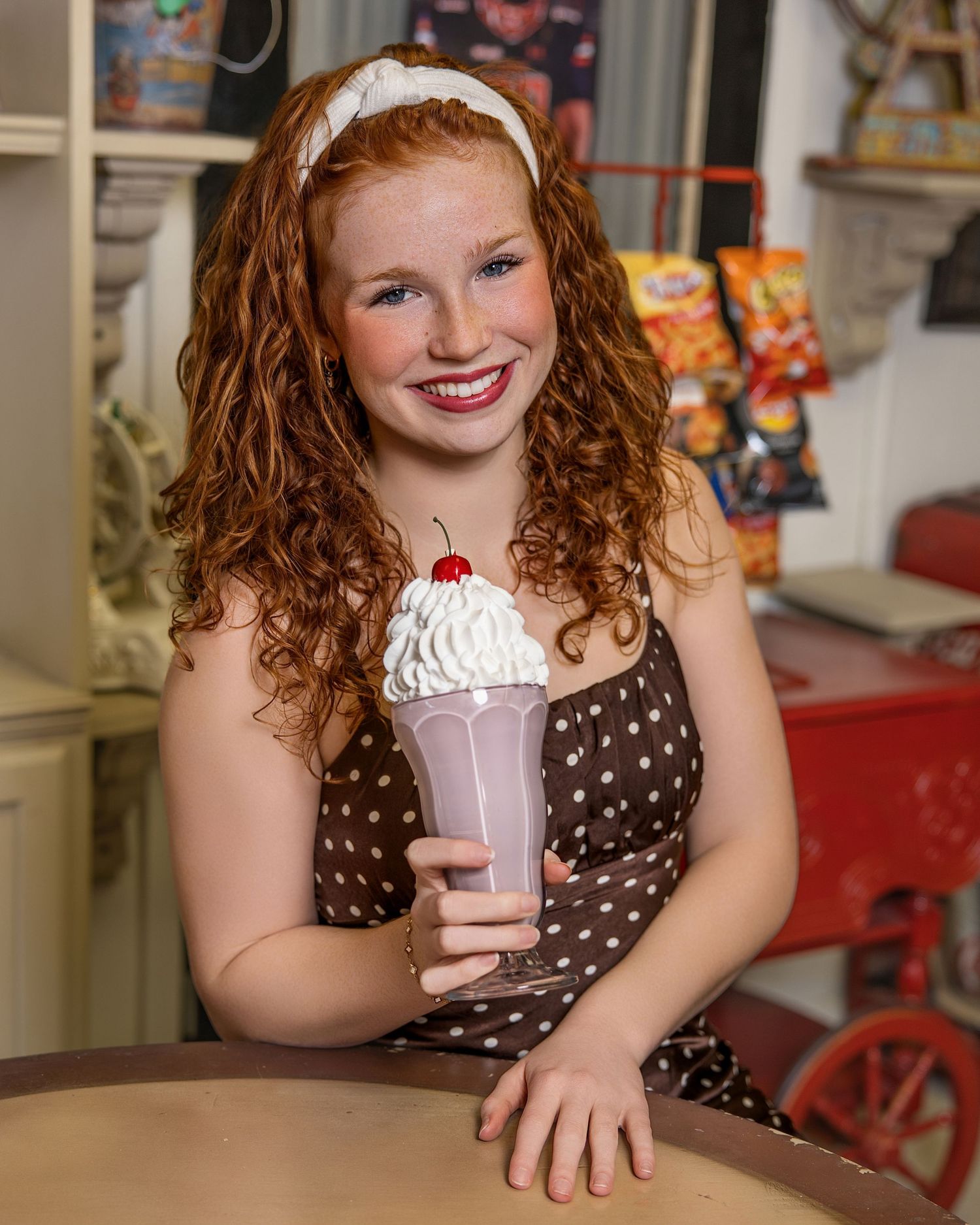 A series of photos showing someone enjoying a milkshake in a retro diner setting with brown polka dot dress.