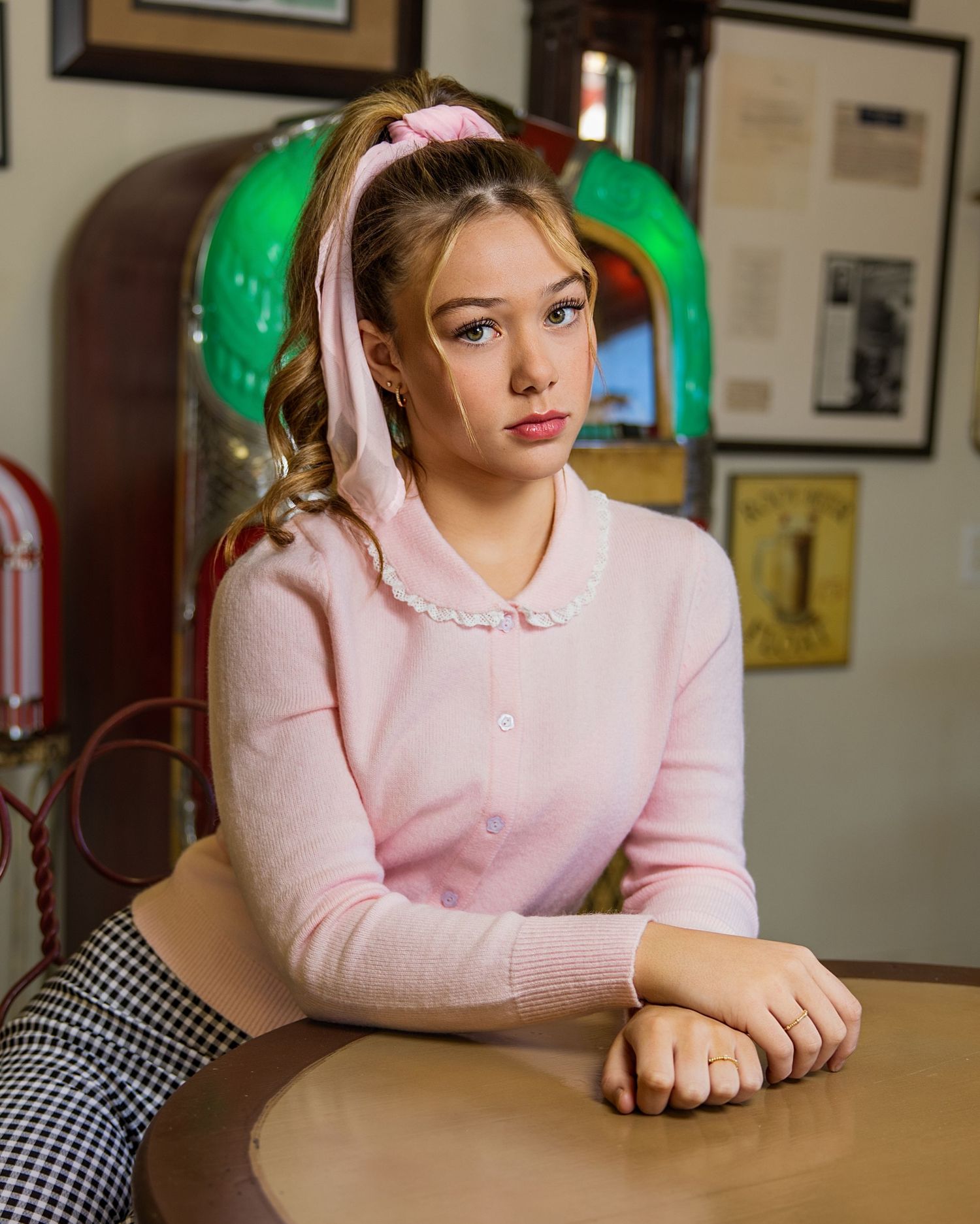 Casual portrait session featuring pink hoodie at a vintage-style restaurant table.