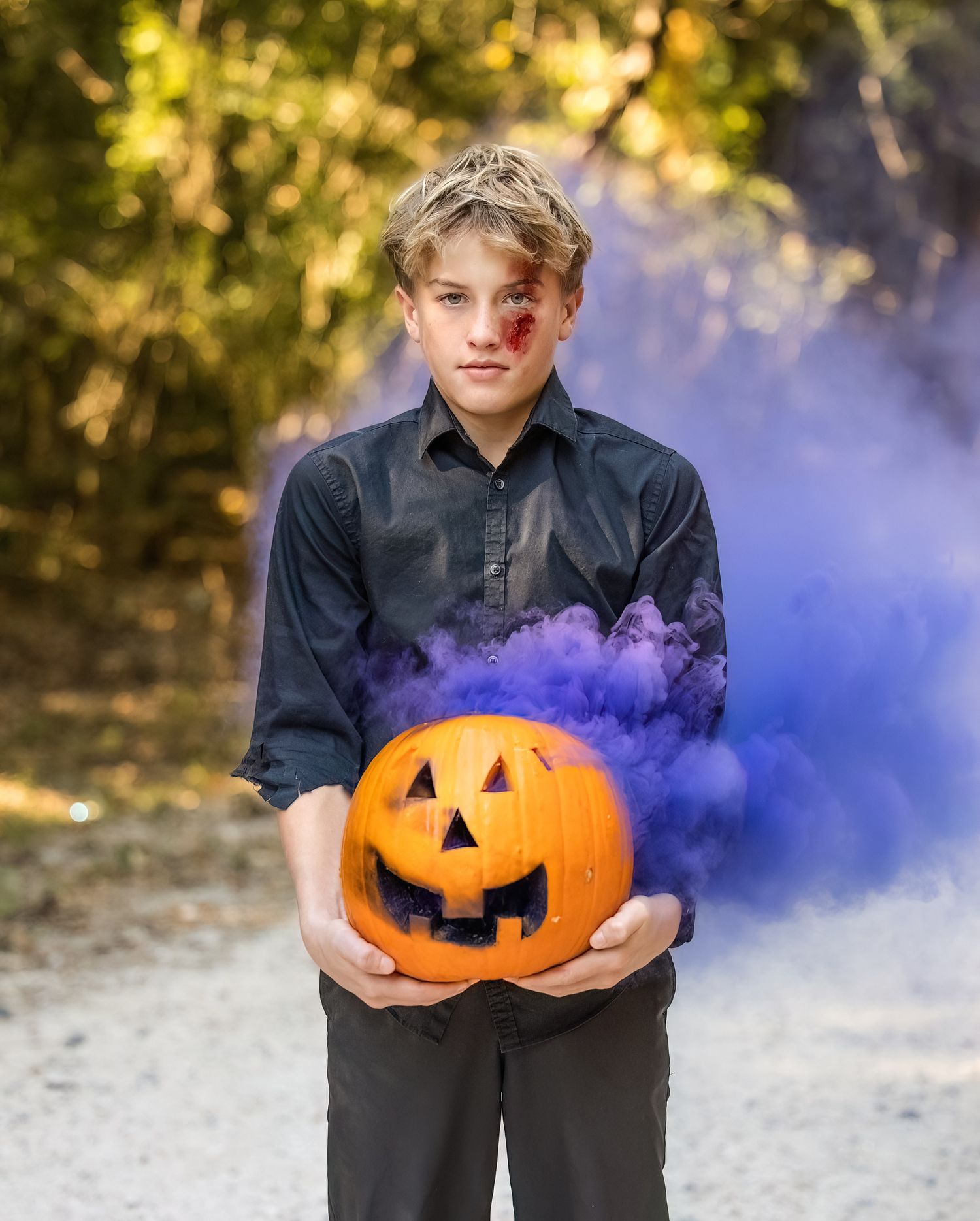 Progressive shots of someone holding a carved pumpkin with blue smoke effects.