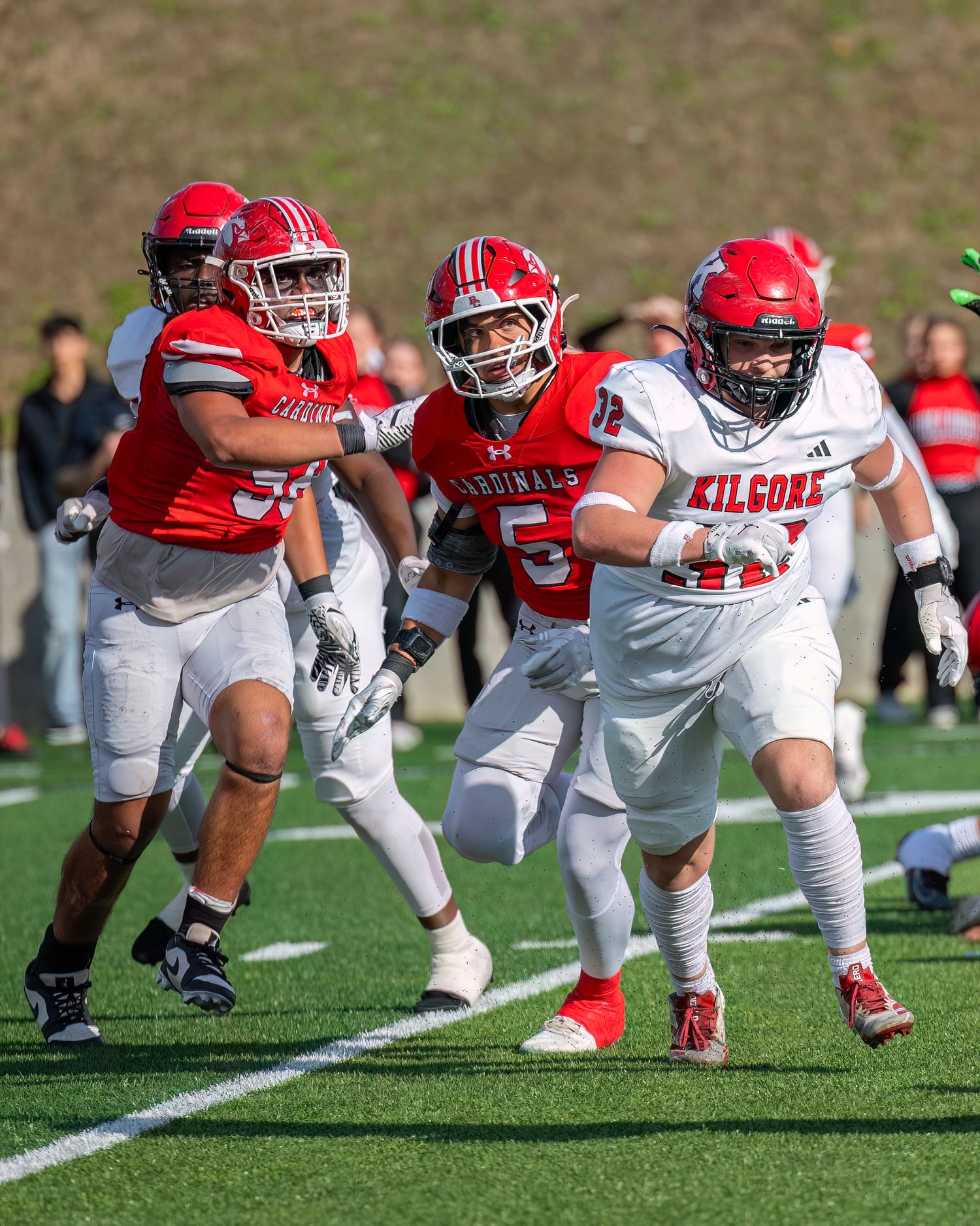 Football players line up in formation on the field during a practice drill.