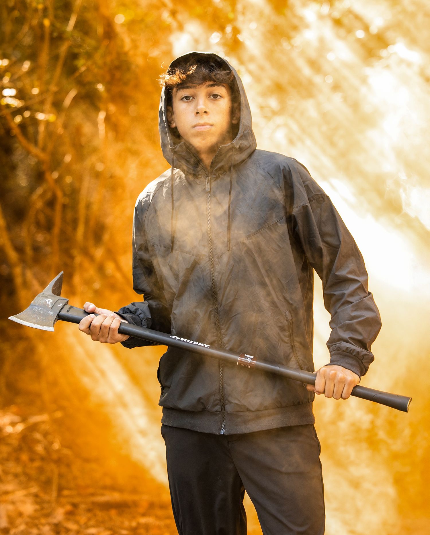 Dramatic portrait sequence with orange lighting and smoke effects featuring a figure in a dark hoodie.