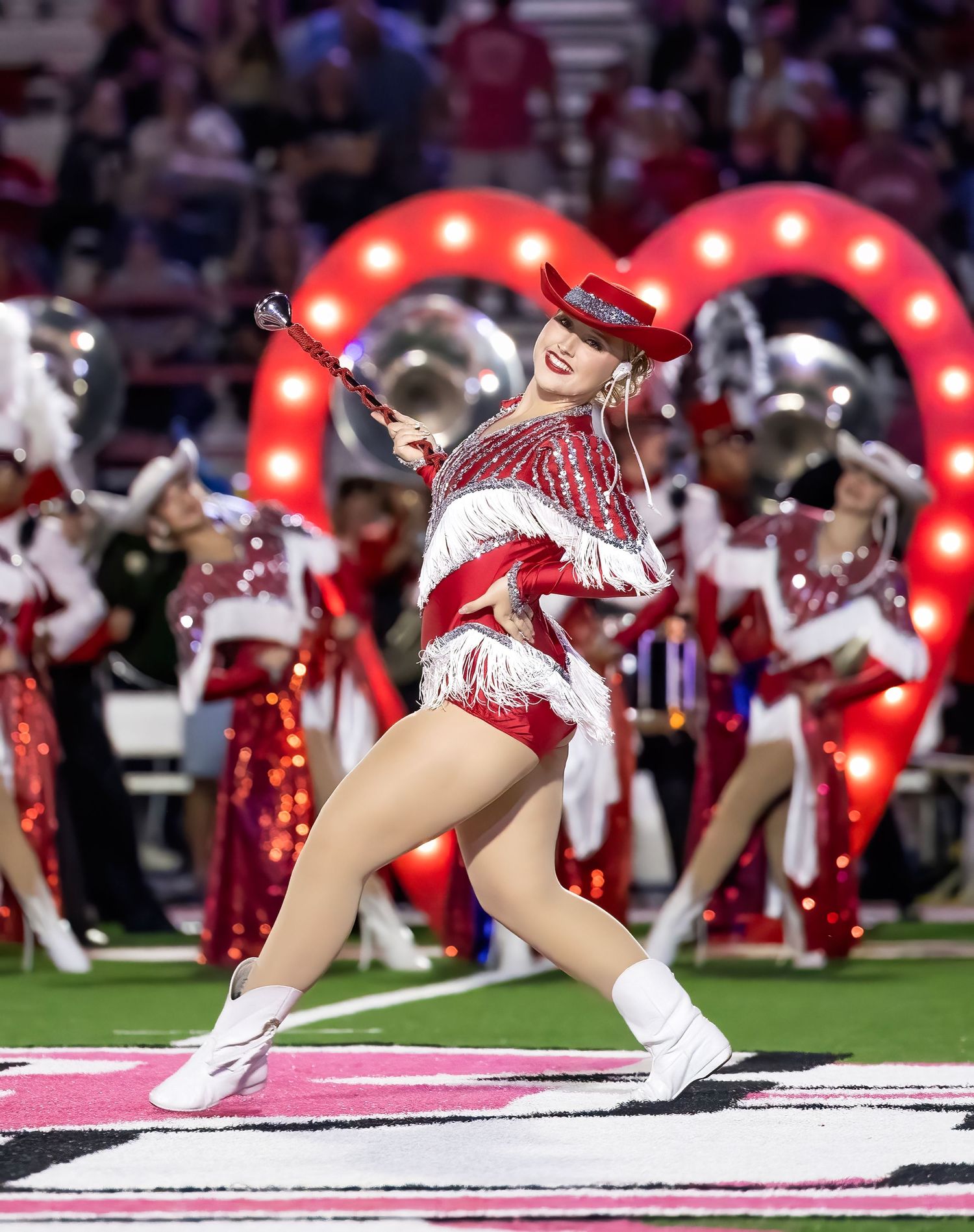 Captain of the Bridge City Strutters performs in red sequined uniforms perform synchronized kicks during halftime show.