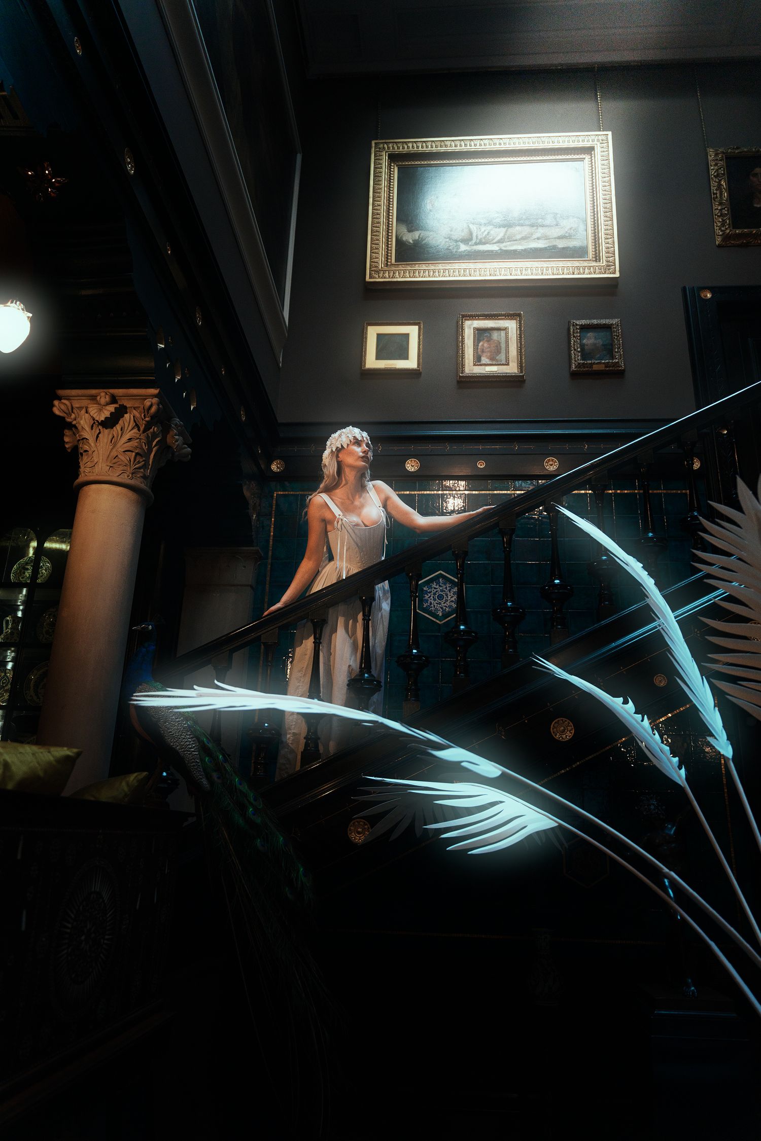Woman in white crown and dress standing on grand staircase with glowing palm leaves.