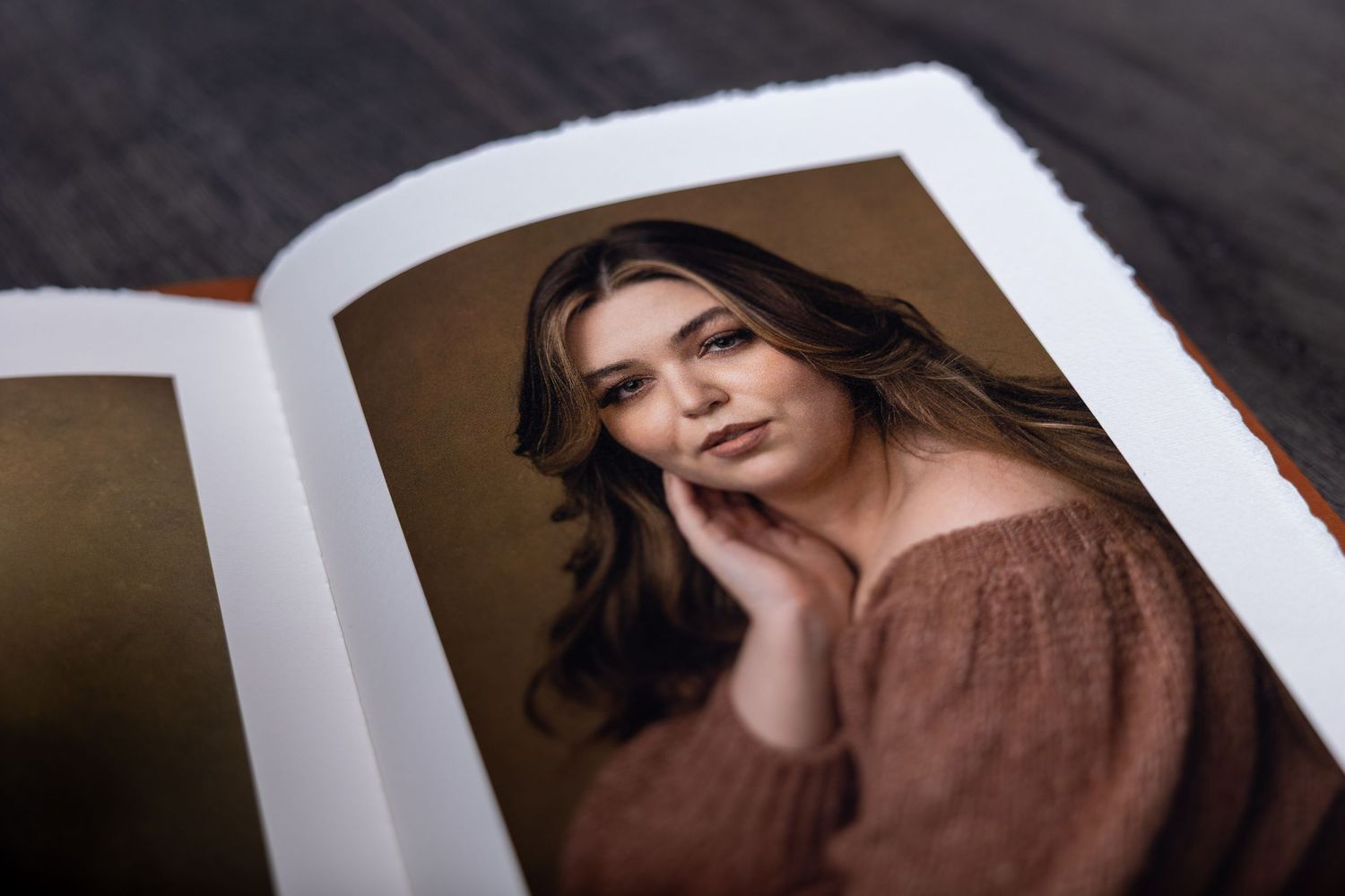 Fashion photography portfolio book displaying glamour portraits with white borders.
