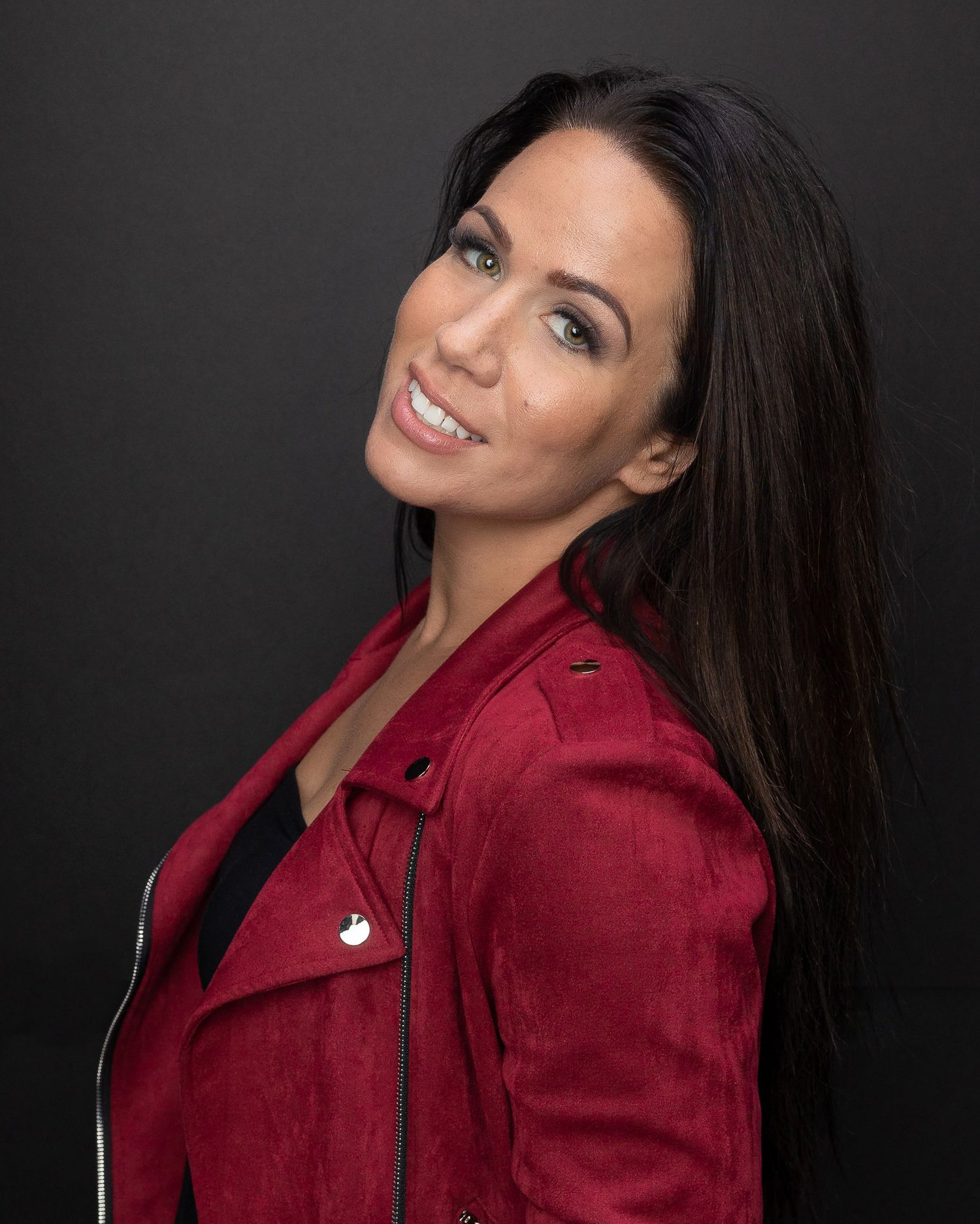 Studio portraits featuring burgundy jacket against dark background with natural expressions.