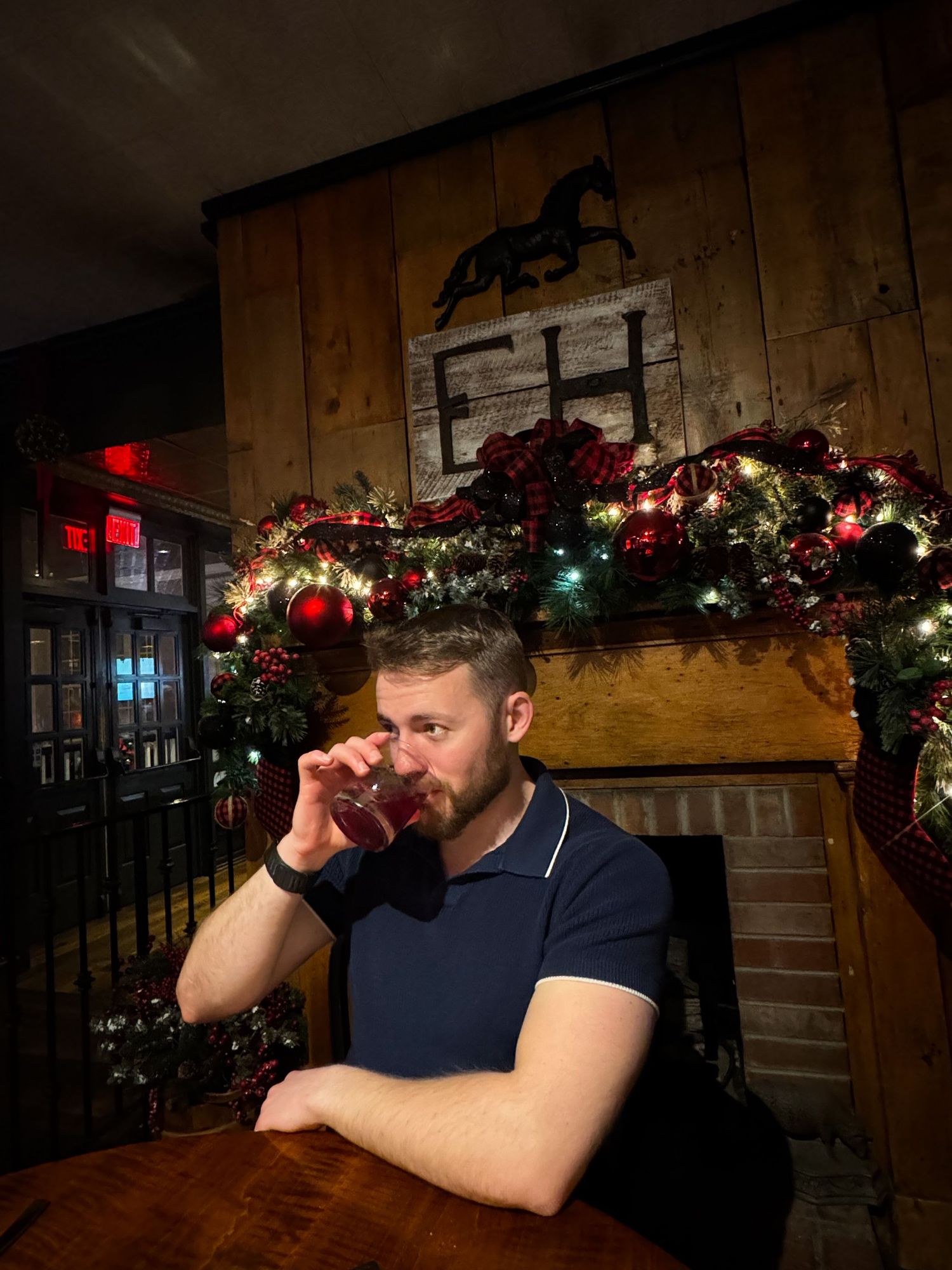 A self portrait of a man drinking an old fashioned with holiday dinner with my family. The background contains the letters EH - my initials