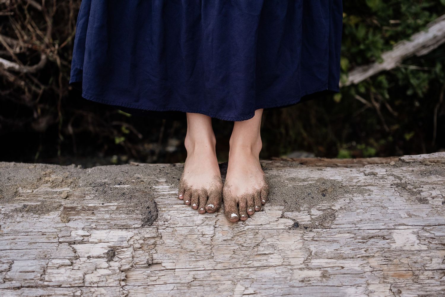 sandy feet standing on a log
