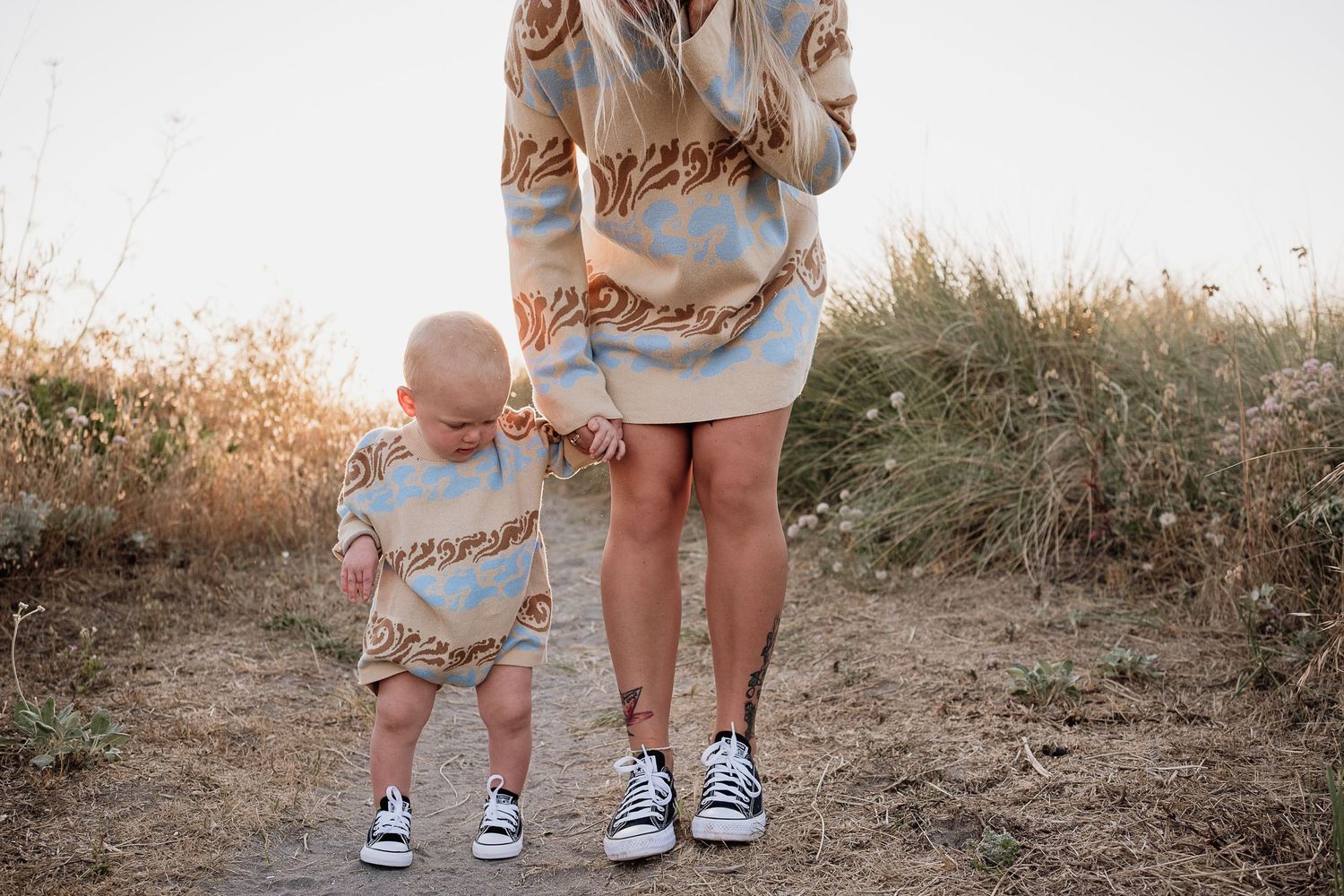 baby and mom holding hands at the dunes with matching shoes and outfits