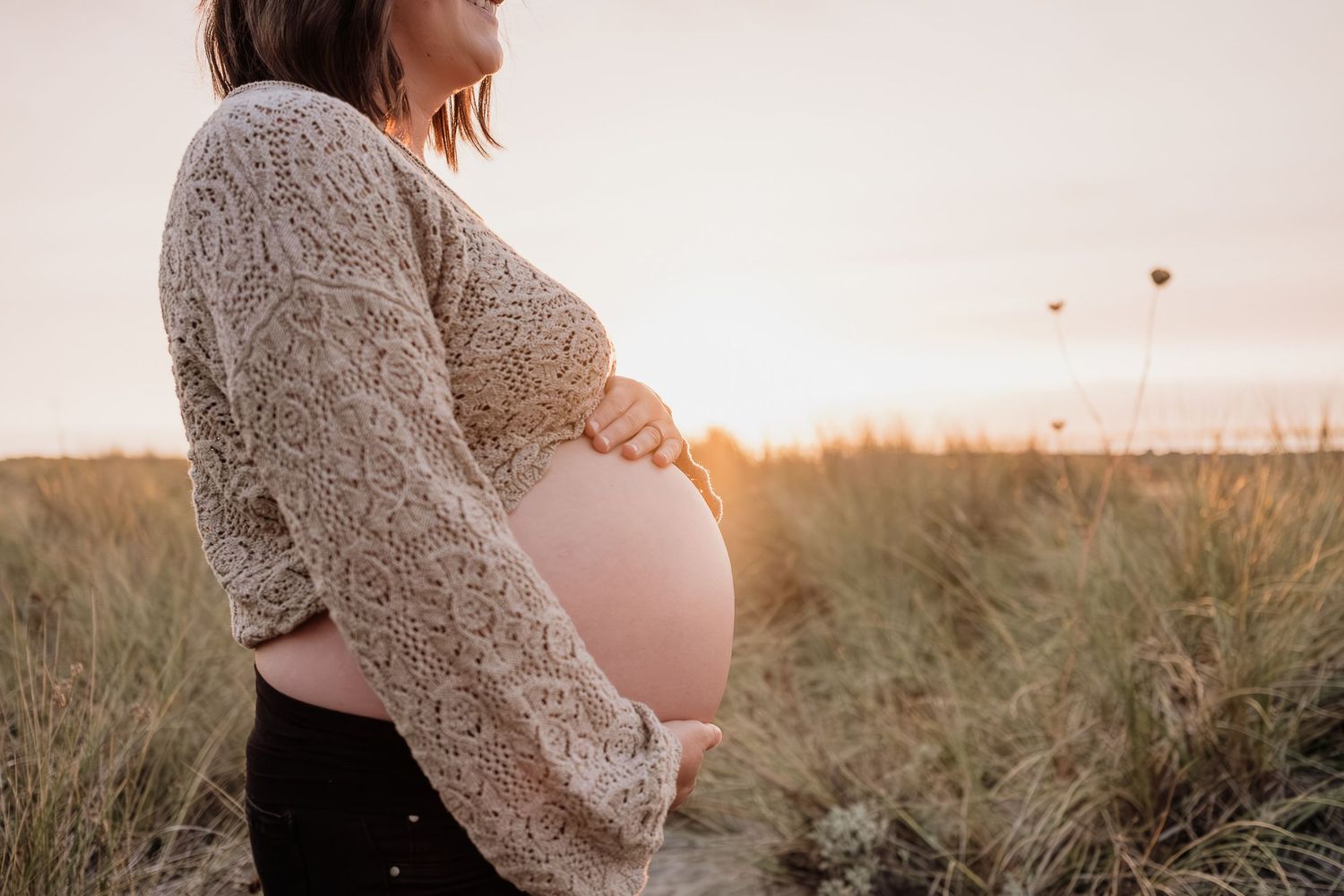 sunset glow on a pregnant tummy at the dunes.