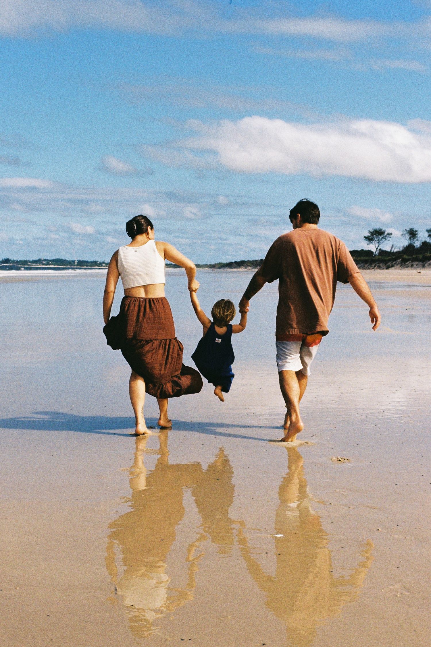 Family walking together along the shoreline.