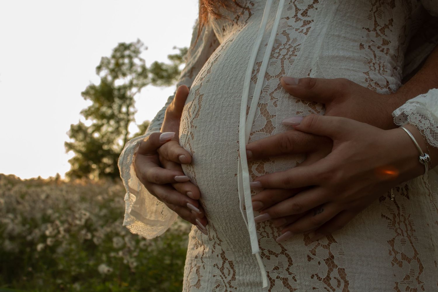Series of intimate maternity photos showing hands on pregnant belly at sunset.