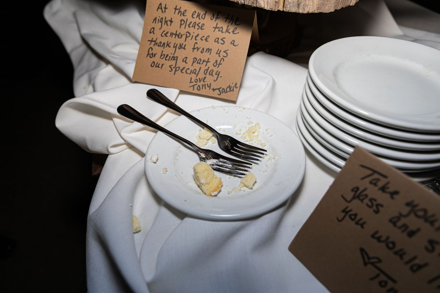 Wedding reception place settings with handwritten cards and elegant tableware.