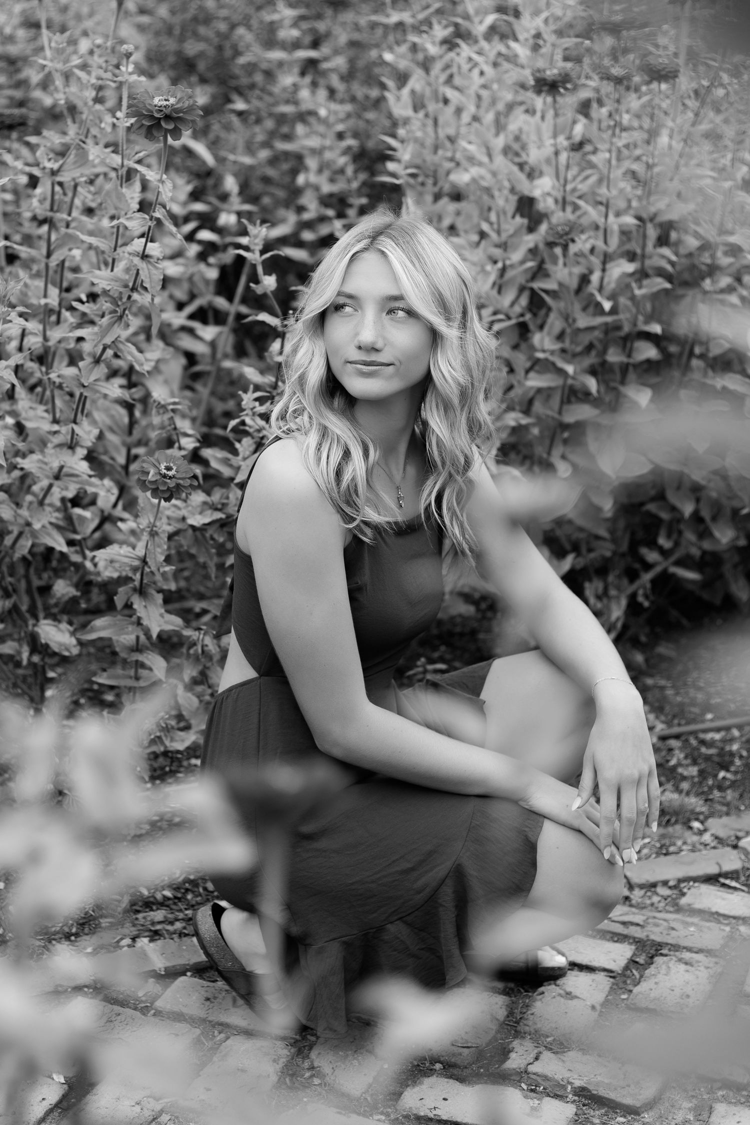 Artistic black and white portraits among foliage with soft focus elements.