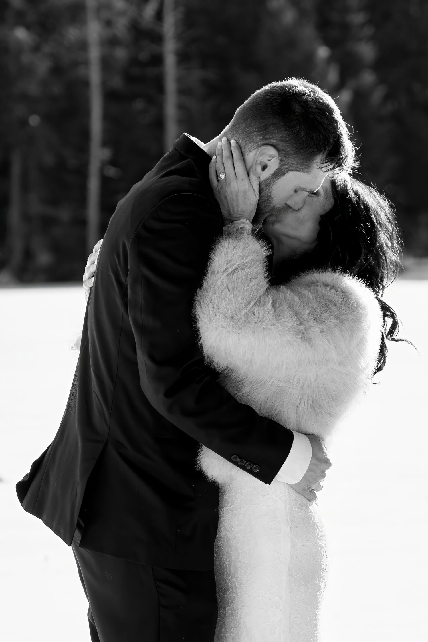 Romantic black and white wedding portraits captured in a snowy winter setting.