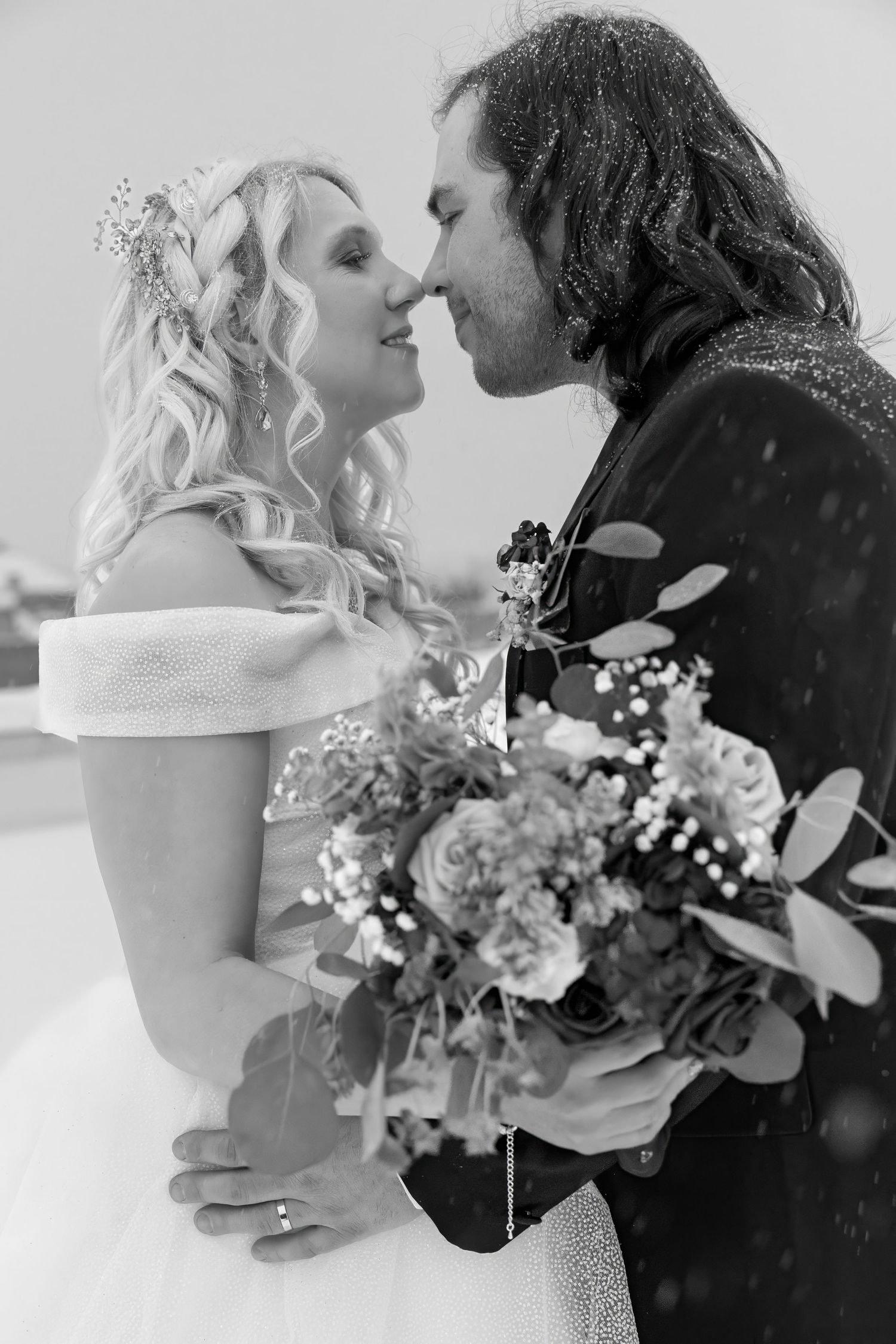 Black and white wedding portrait with delicate floral bouquet details.