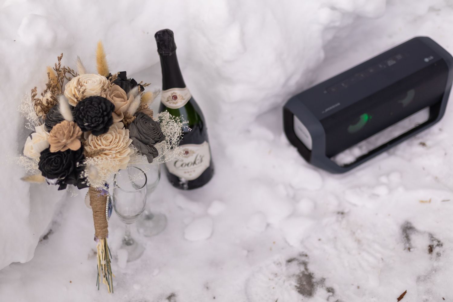 Wedding bouquet and audio equipment arranged in snow.