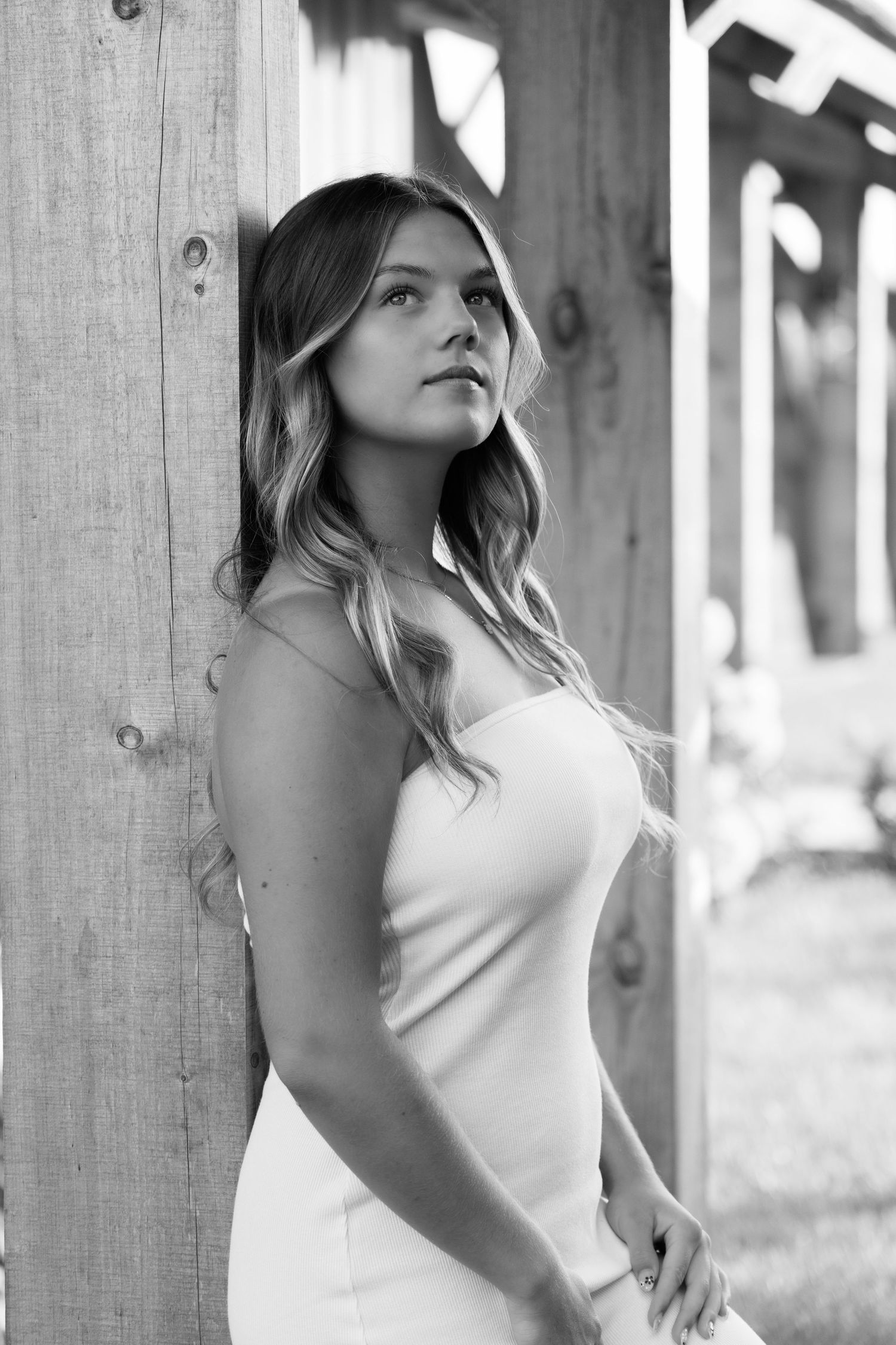 Black and white portrait series against rustic wooden backdrop in casual attire.