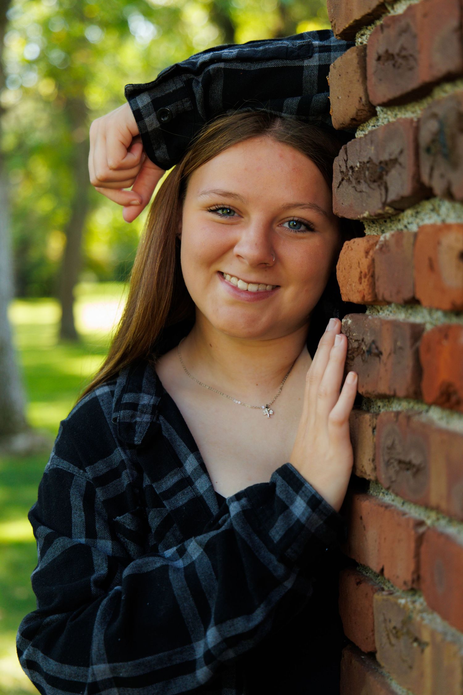Portrait series against a rustic brick wall featuring casual attire and natural lighting.