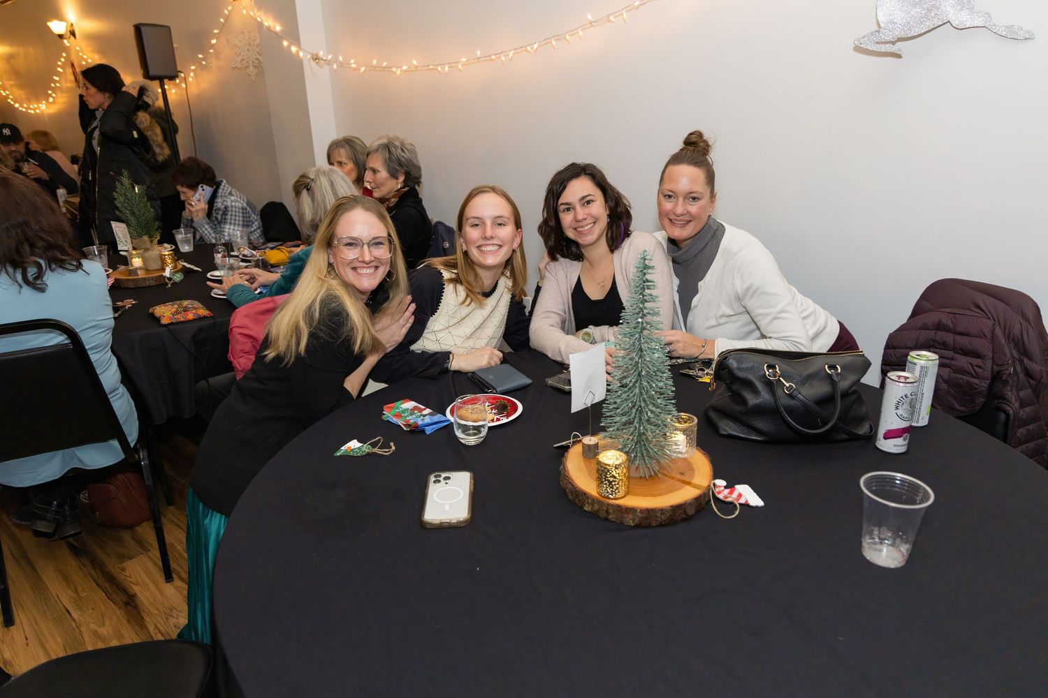 A cozy indoor gathering space decorated with string lights and tables.