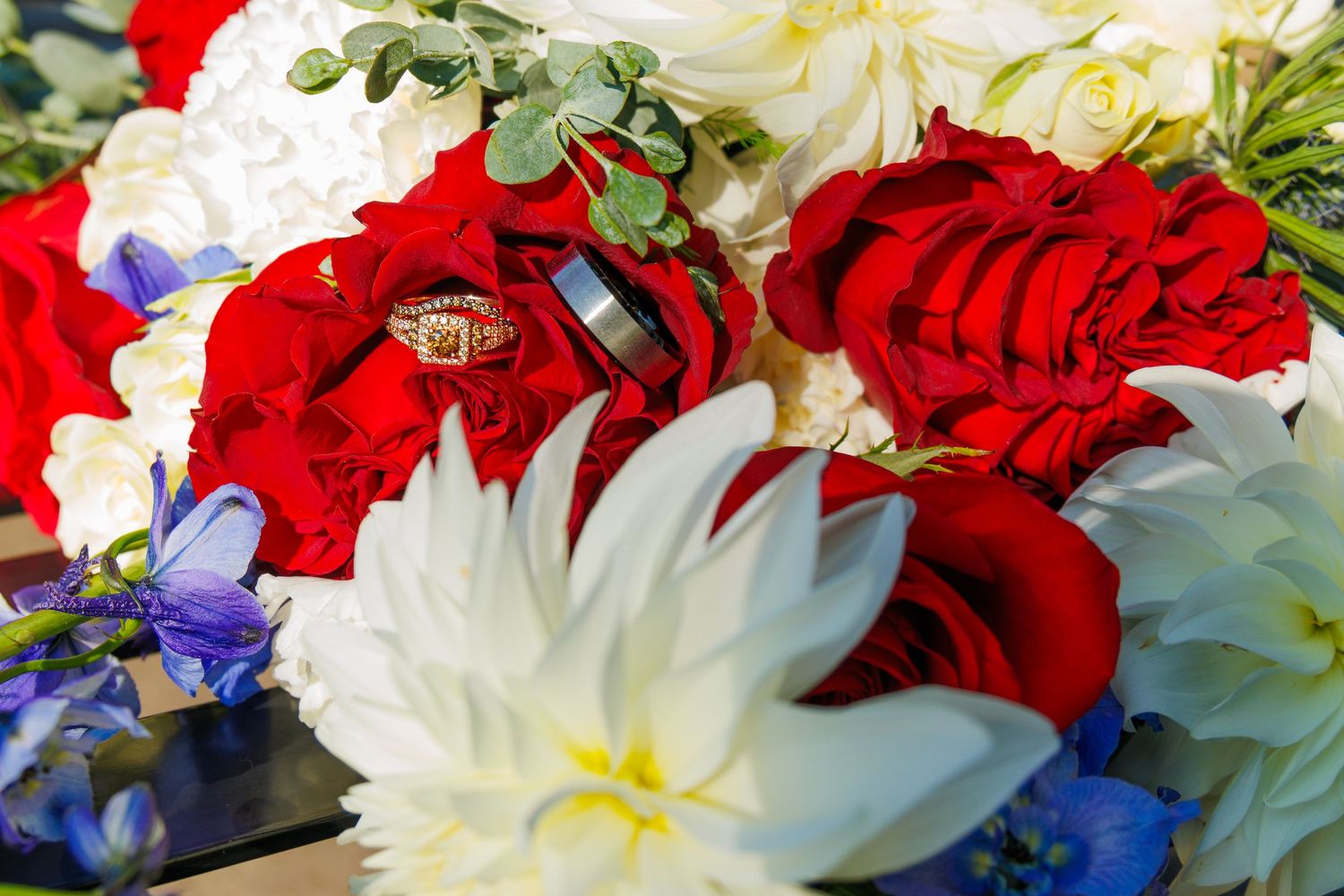 Vibrant floral arrangement featuring red and white flowers with blue accents.