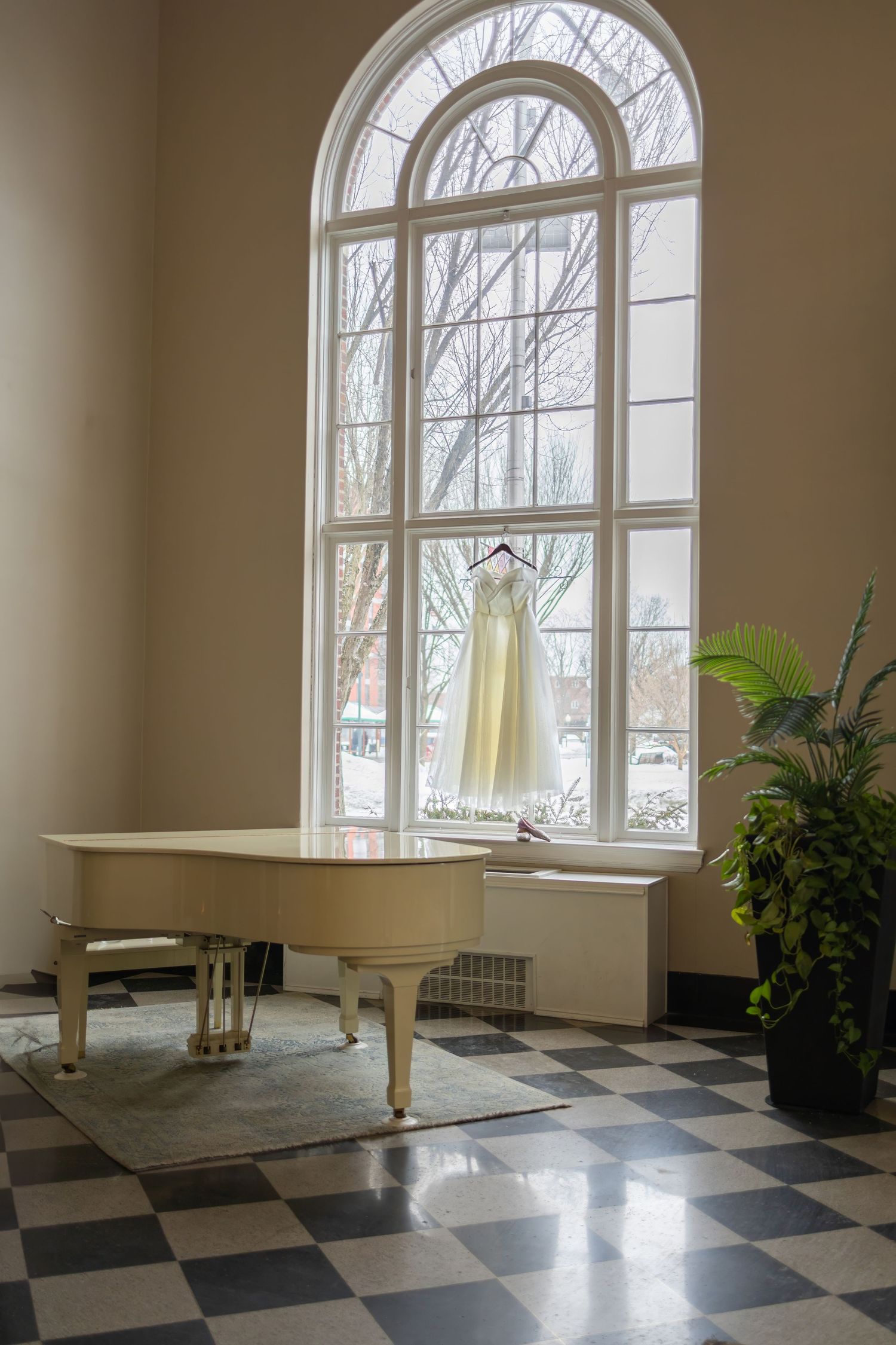 Elegant room with arched windows, checkered floor, and natural light streaming in.