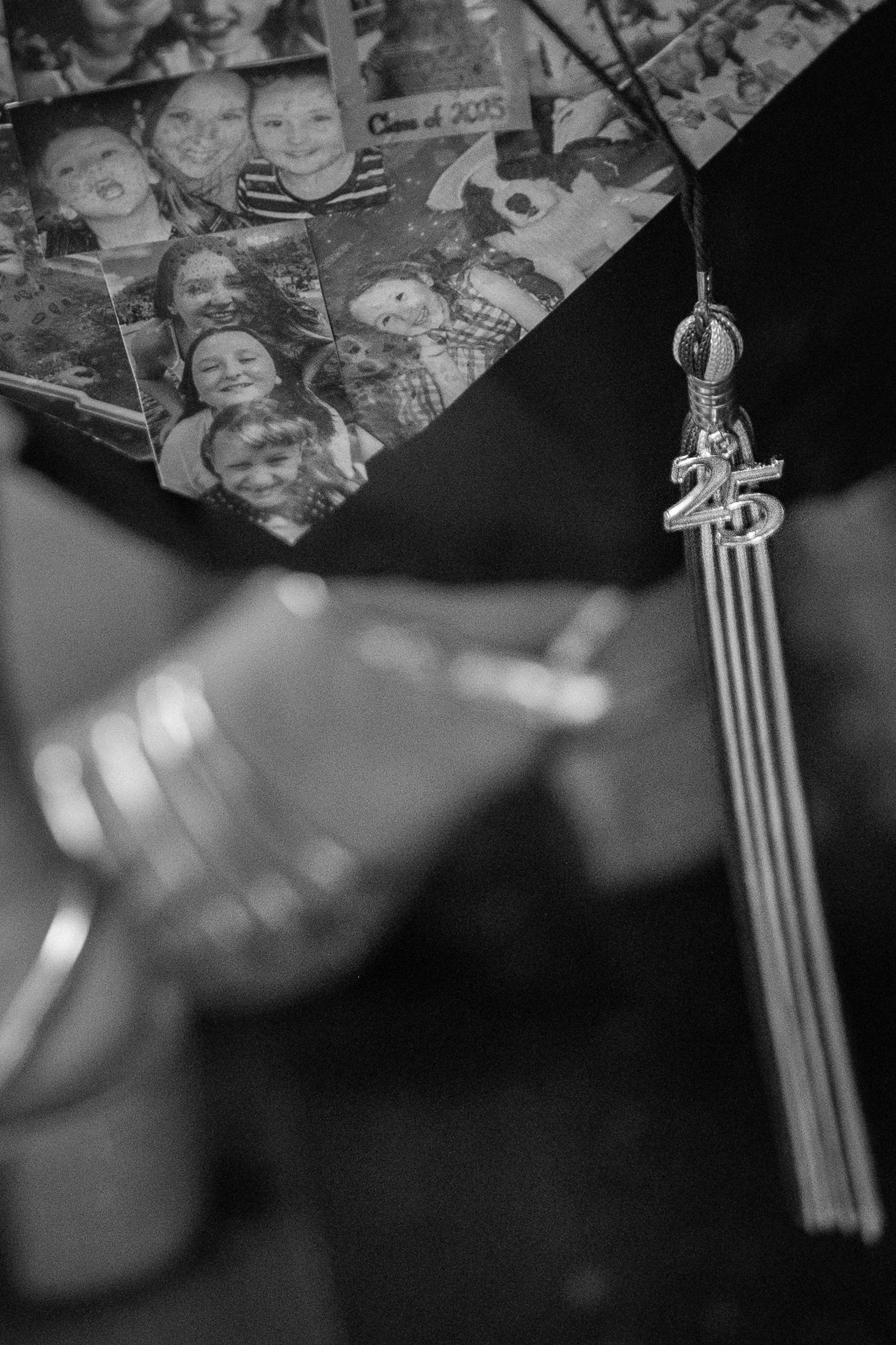 Black and white detail of graduation tassel with class year charm.