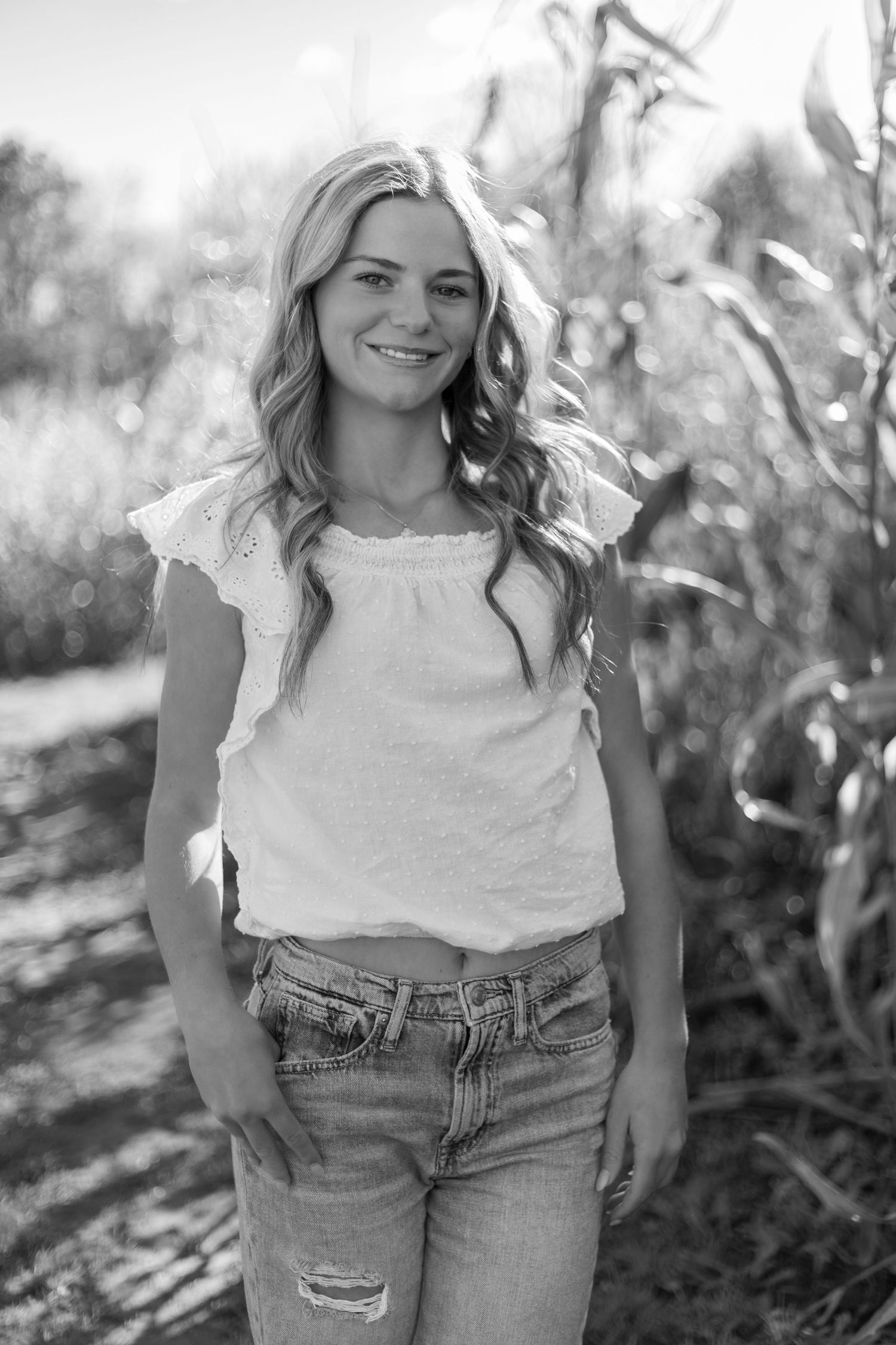 Black and white portrait series showing casual poses in distressed denim and white top.