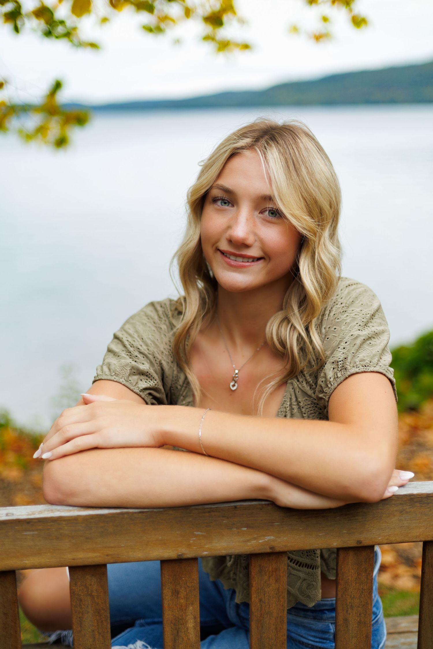 Relaxed outdoor portraits on a wooden railing with a lake view in the background.
