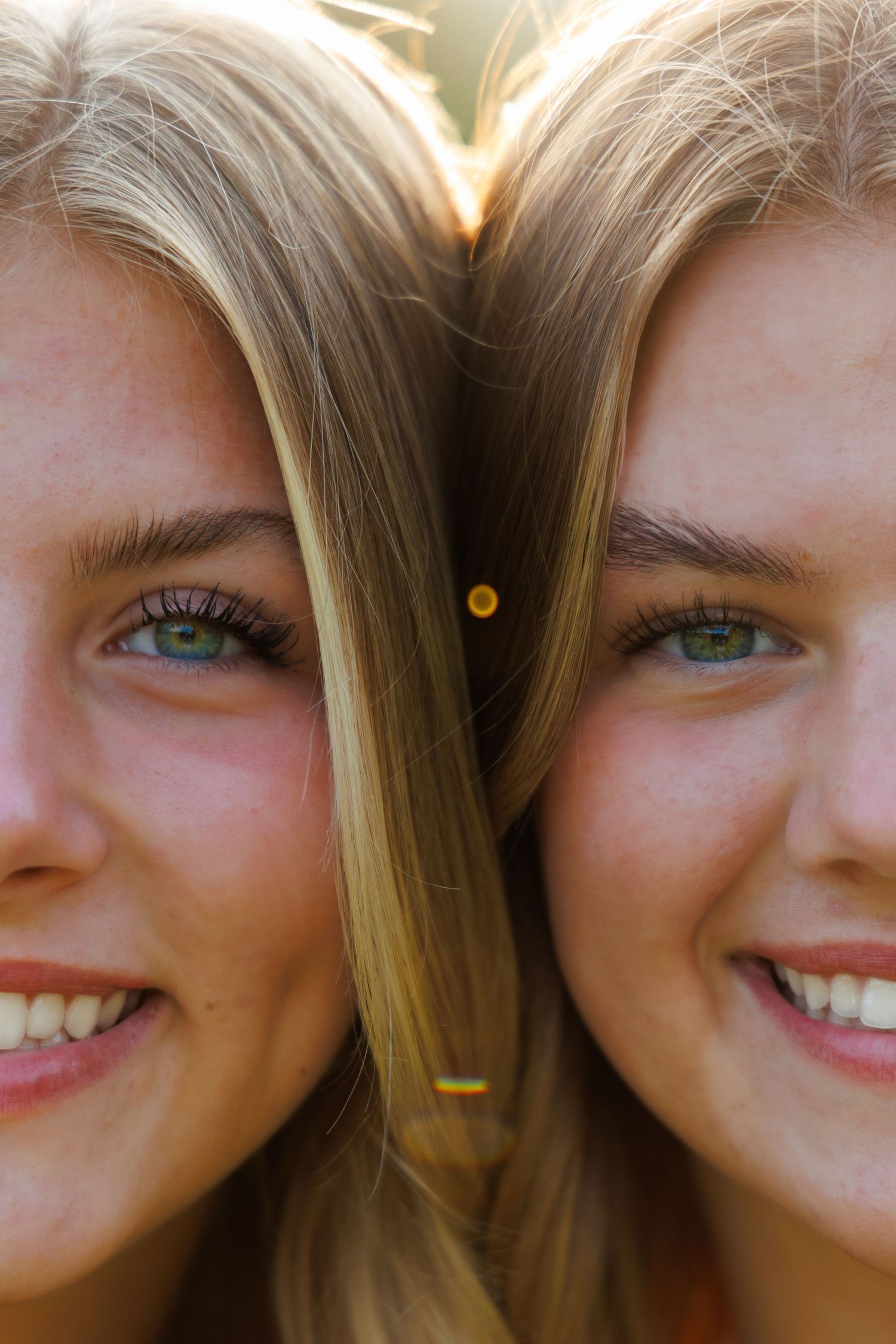 Close up of bright smiling eyes and blonde hair against a warm background.