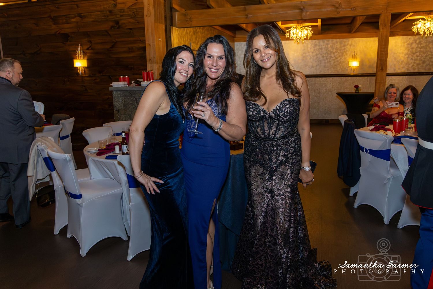 Elegant evening event with guests in formal attire dancing under warm lighting.