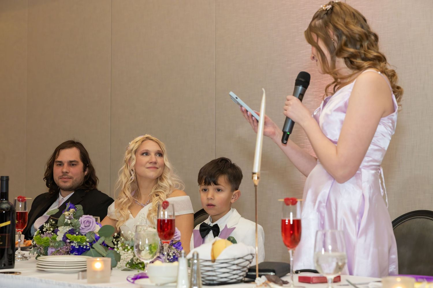 Wedding reception table setup with drinks and decorations as guests celebrate.