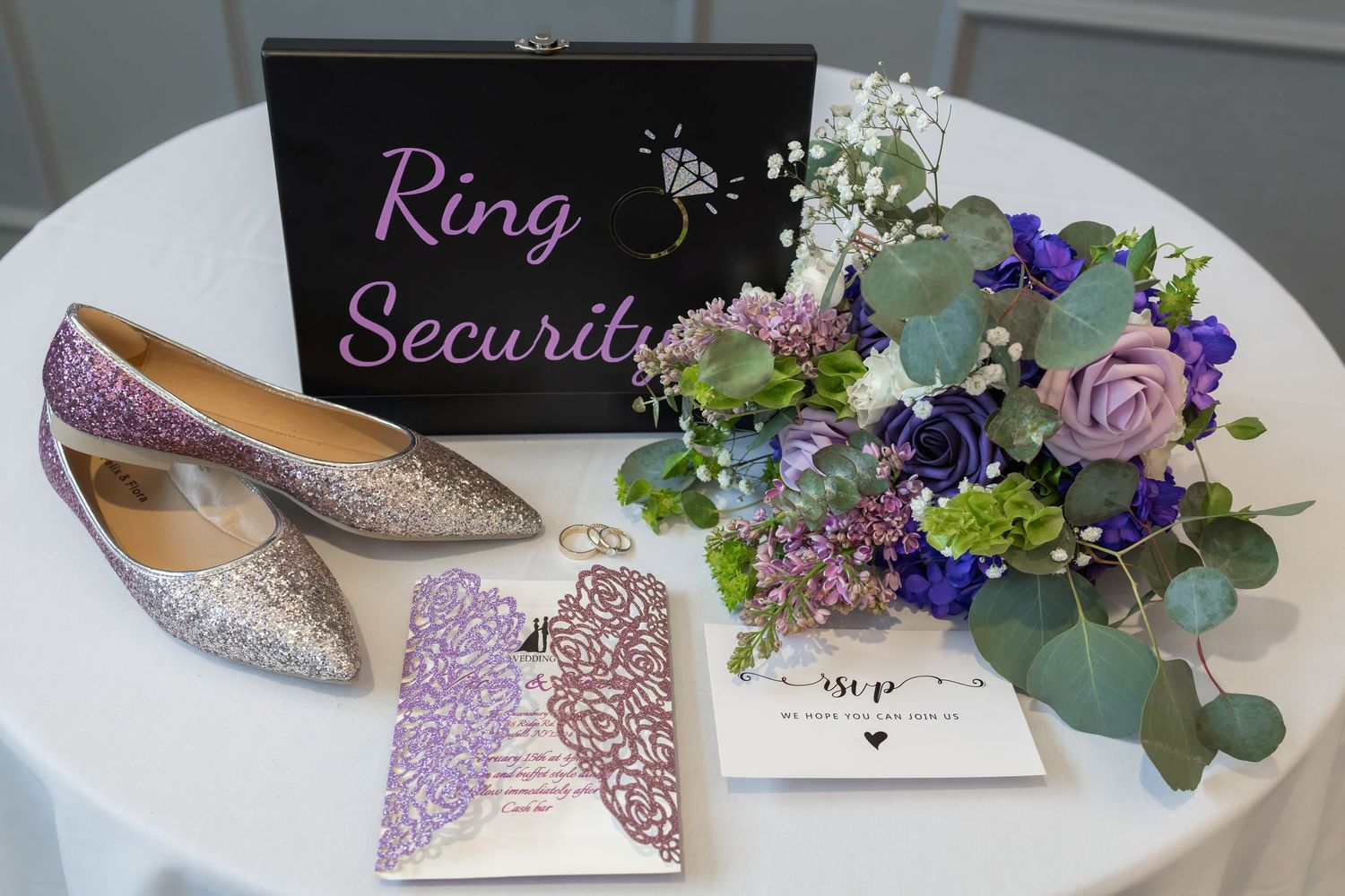 Wedding details including sparkly shoes and ring security signs with floral accents.
