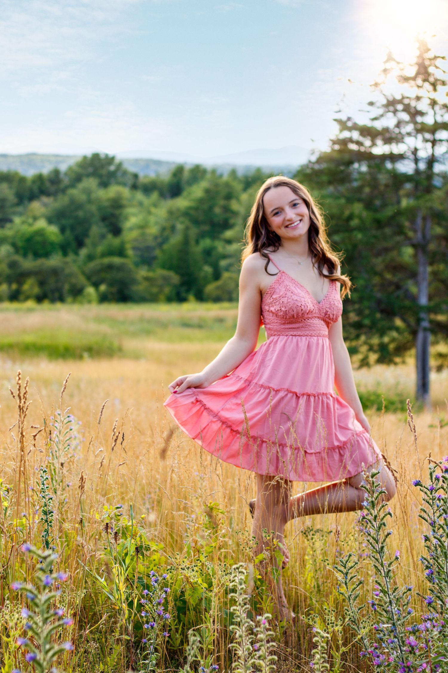A pink ruffled dress catches sunlight in a field of summer wildflowers.