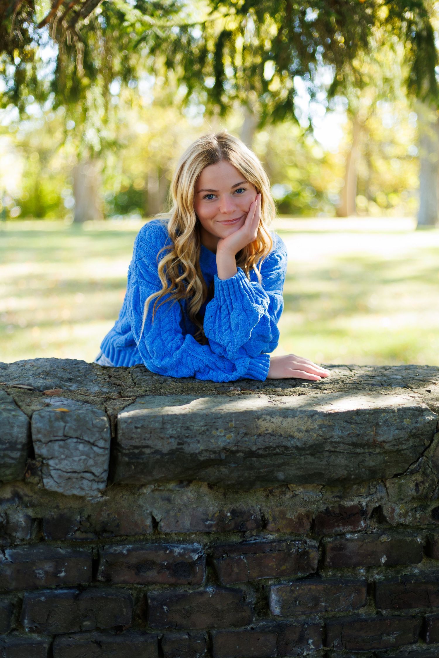 A series of casual poses on a stone wall with green foliage in the background.
