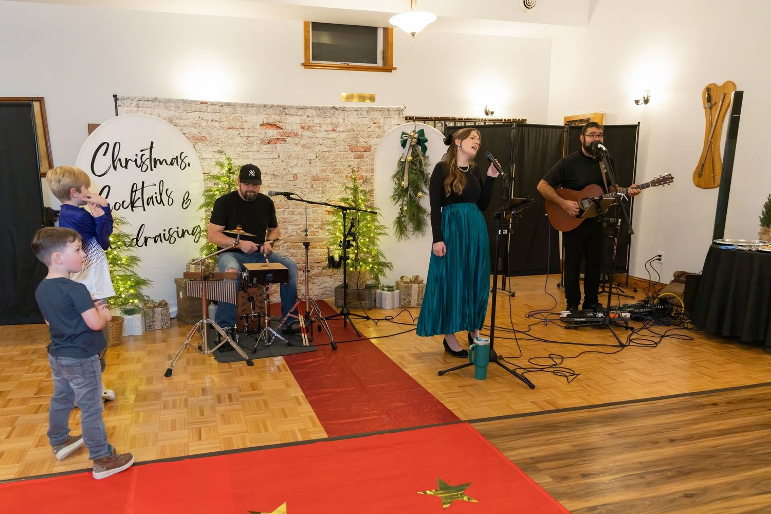 Wide view of performance space with musical equipment and holiday decorations.