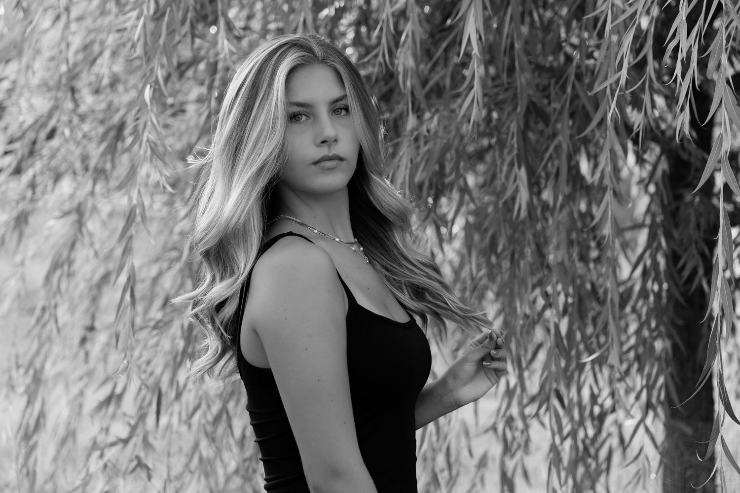 Dramatic black and white portraits under weeping willow branches.