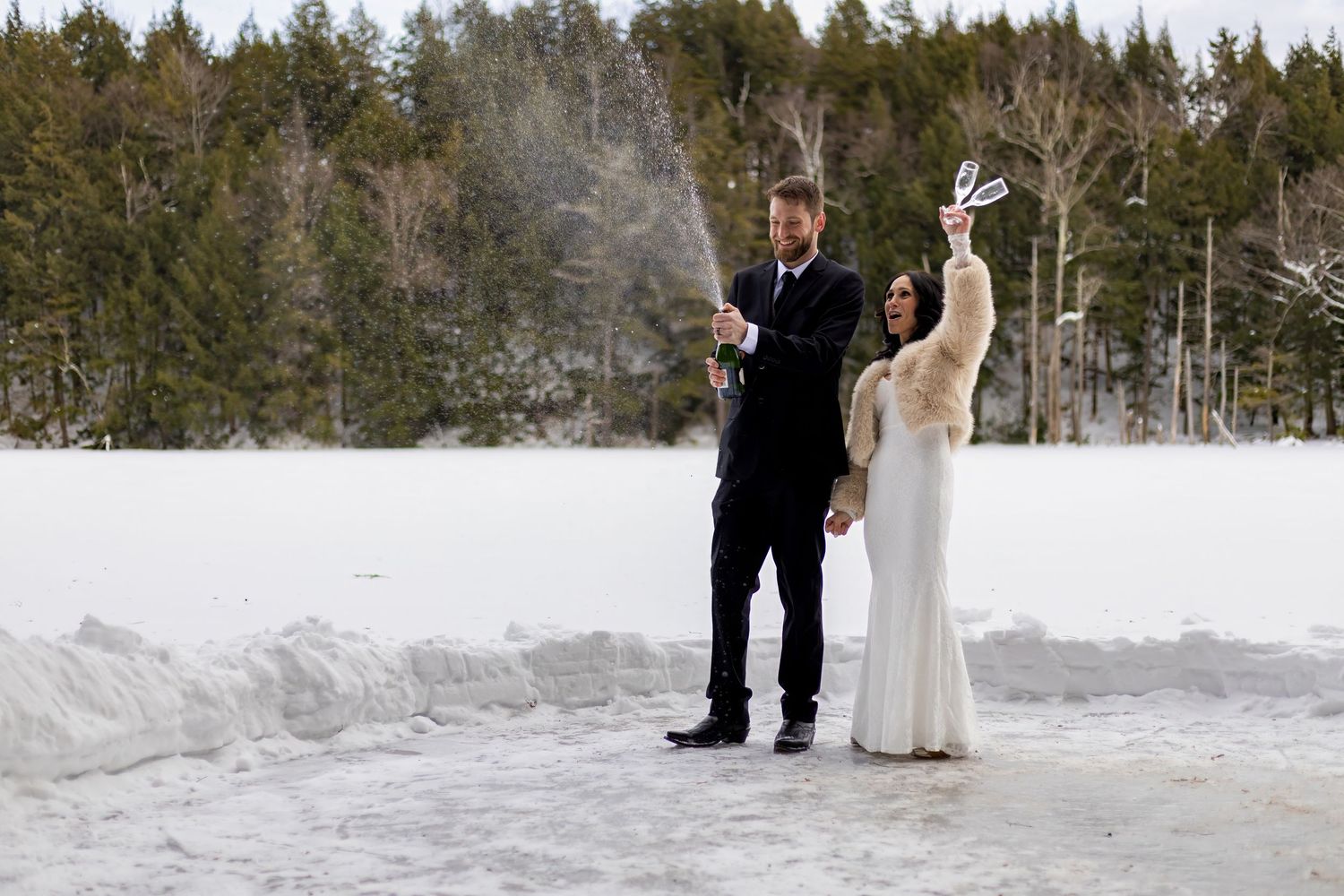 Wide landscape wedding photos in snowy forest setting with evergreen trees.