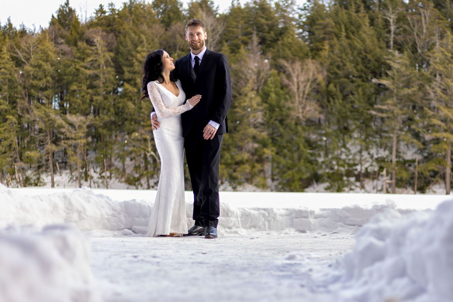 Snow-covered winter landscape with evergreen trees creating romantic wedding backdrop.