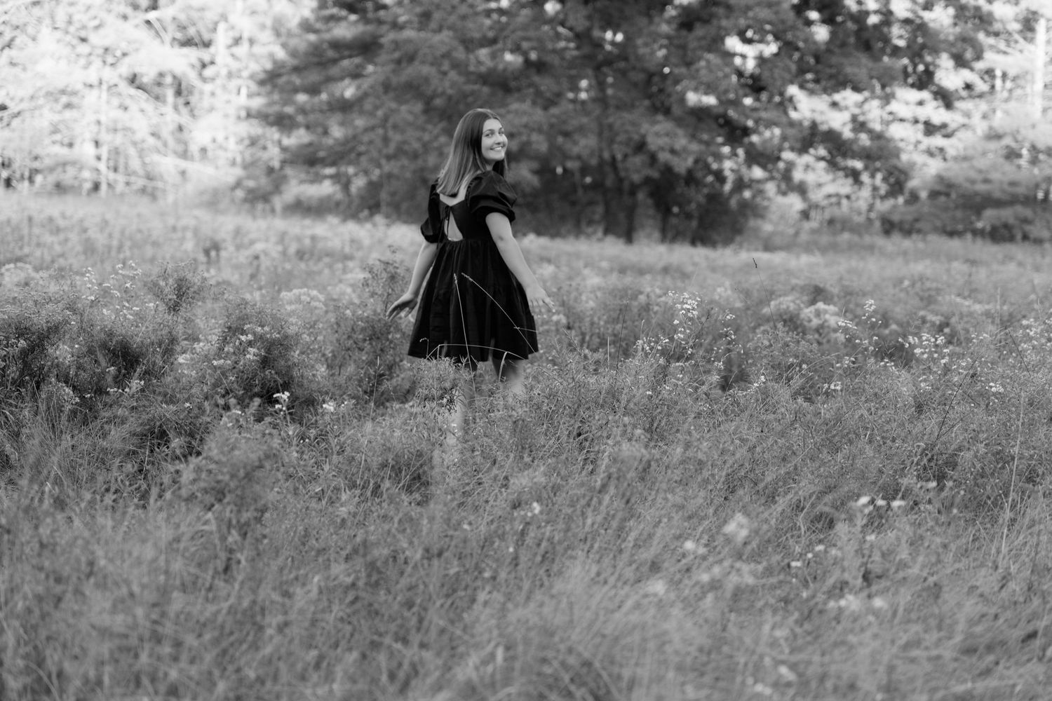 Black and white portraits taken in a rustic outdoor setting with natural foliage.