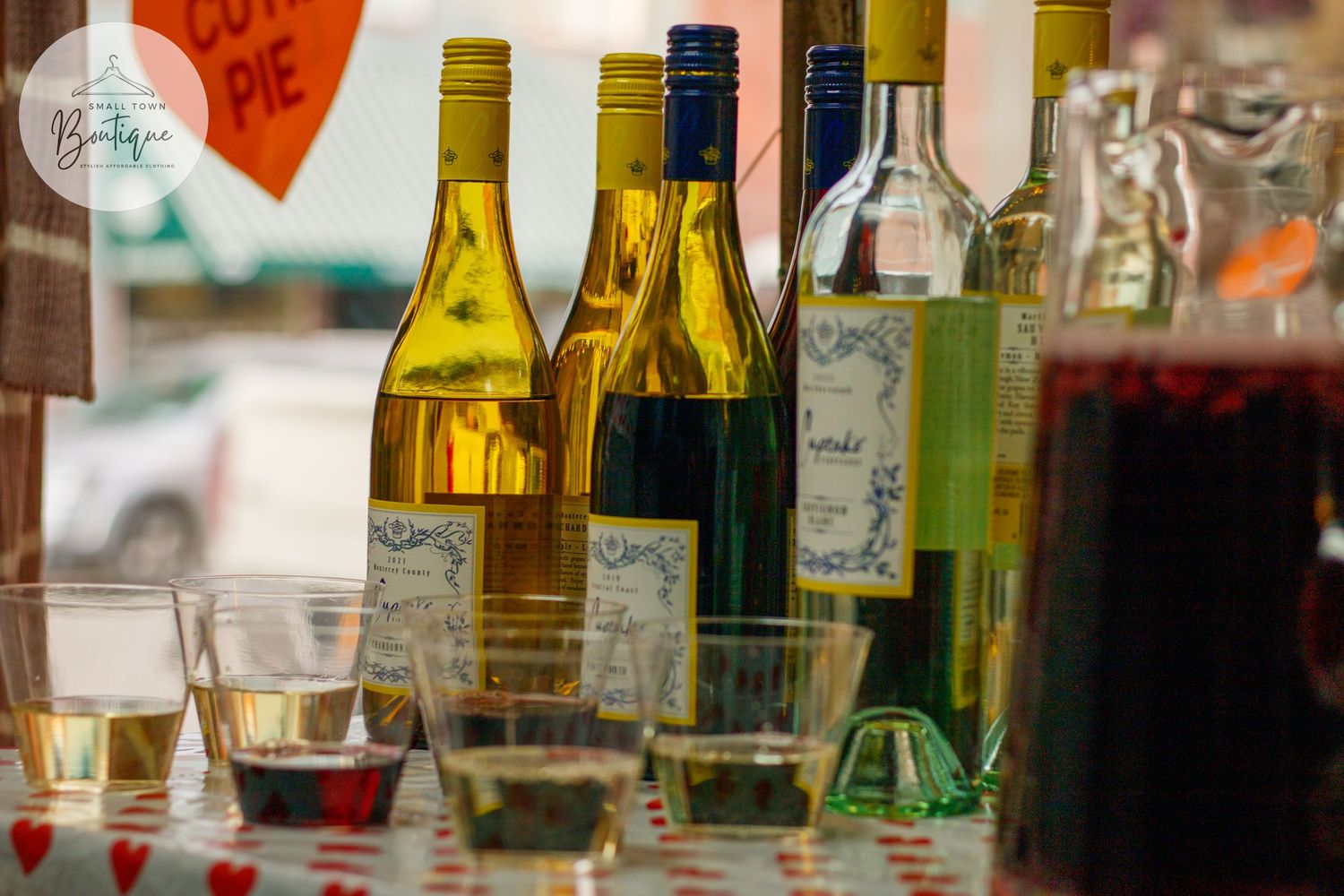 Assorted wine and liquor bottles displayed on a bar shelf with colorful lighting.